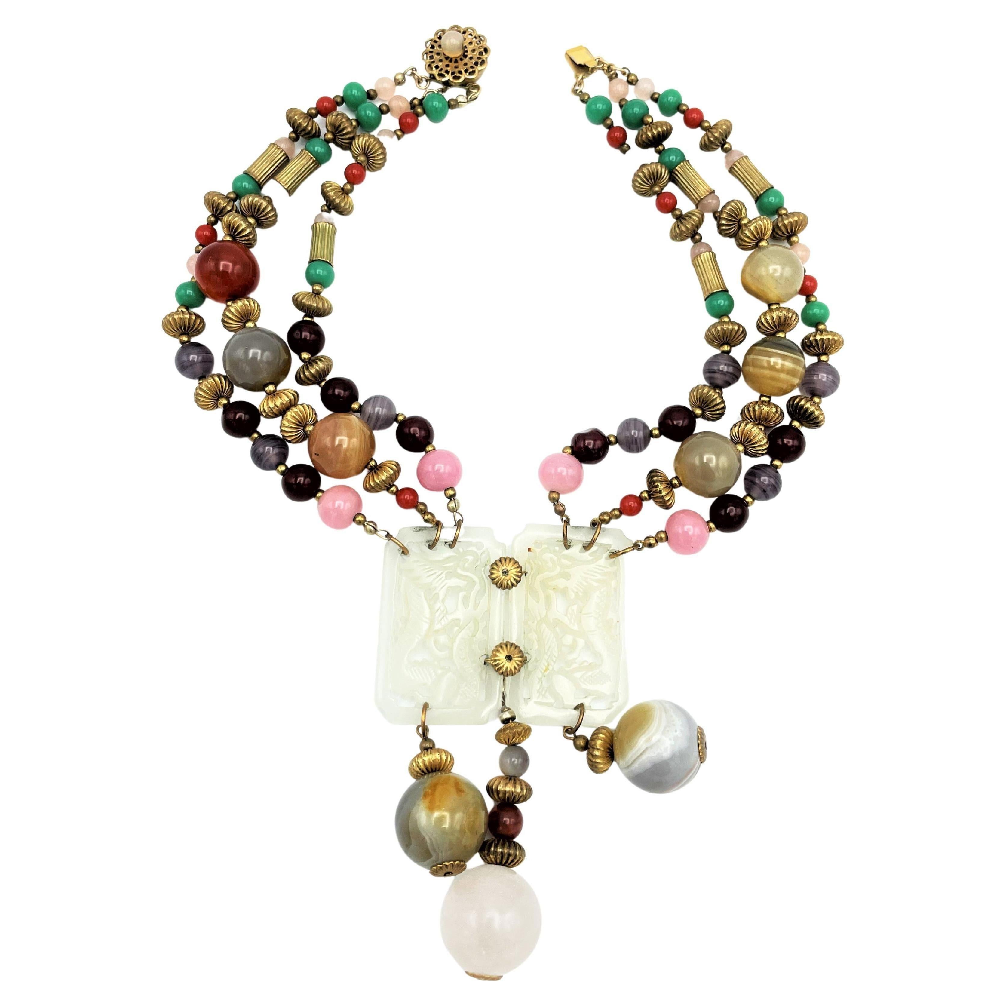 Un collar muy interesante de Miriam Haskell de principios de la década de 1950. Compuesto por bolas de ágata más grandes y más pequeñas y bolas de cristal más pequeñas. En el centro hay dos piezas talladas de 5 x 3 cm de material similar al jade. De