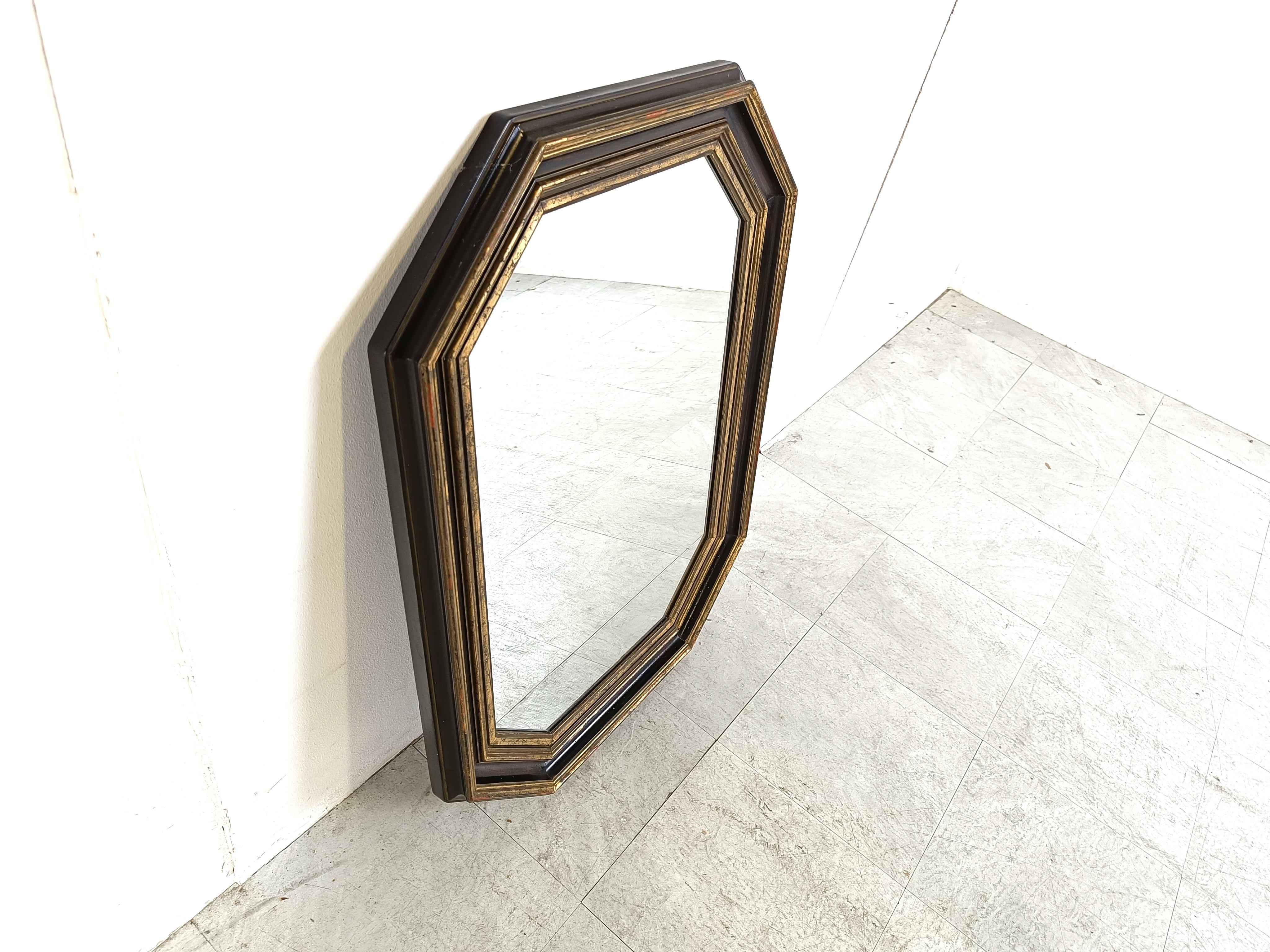 Seventies wall mirror made in Belgium.

Octogonal design with a gilt and ebonized wooden frame.

This mirror was made by Deknudt.

1970s - Belgium

Dimensions:
Height: 85cm/33.46
