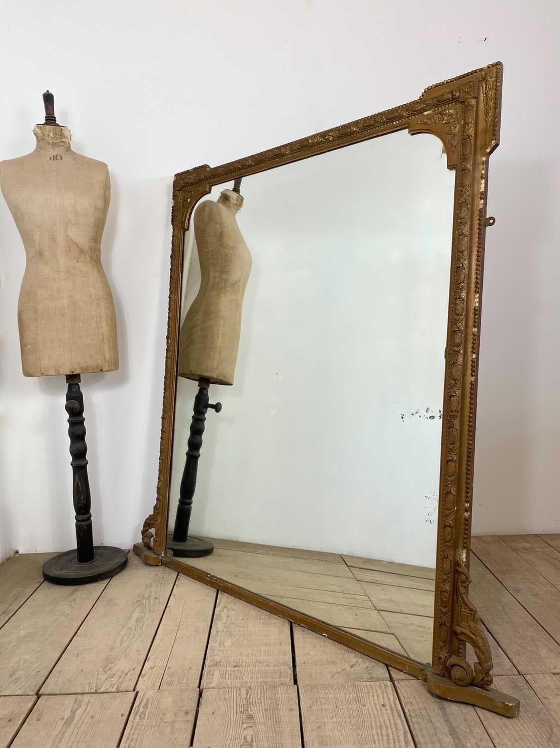 Miroir de cheminée vintage avec un cadre doré détaillé. Le cadre présente des détails incroyables au niveau de la forme et des ornements. Il y a quelques pièces manquantes ou des éclats sur le cadre qui créent une sensation vintage avec beaucoup de
