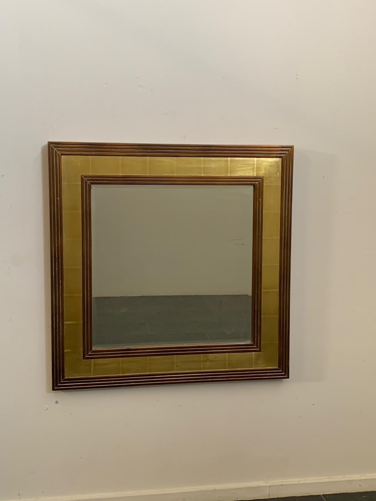 Un miroir singulier et unique avec un cadre en bois orné de feuilles métalliques décoratives.
Les bords et le centre présentent des sculptures rayées avec une finition rouge-bronze, tandis que le centre présente une patine dorée saisissante avec des