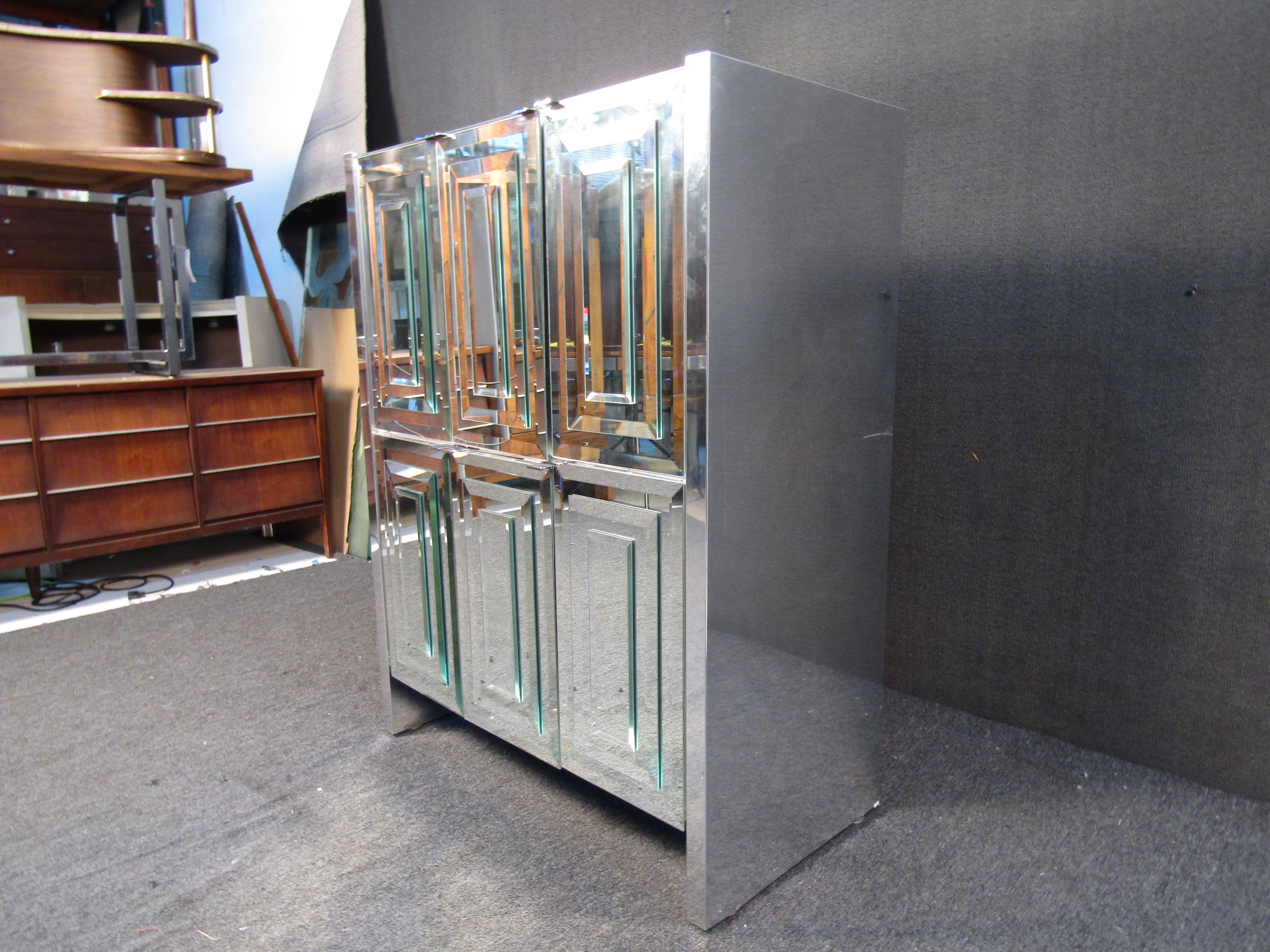 This modern-style cabinet shows off an eye-catching mirrored surface with bevelled panels. Two doors open to reveal a storage compartment and three large drawers. Please confirm item location with seller (NY/NJ).
