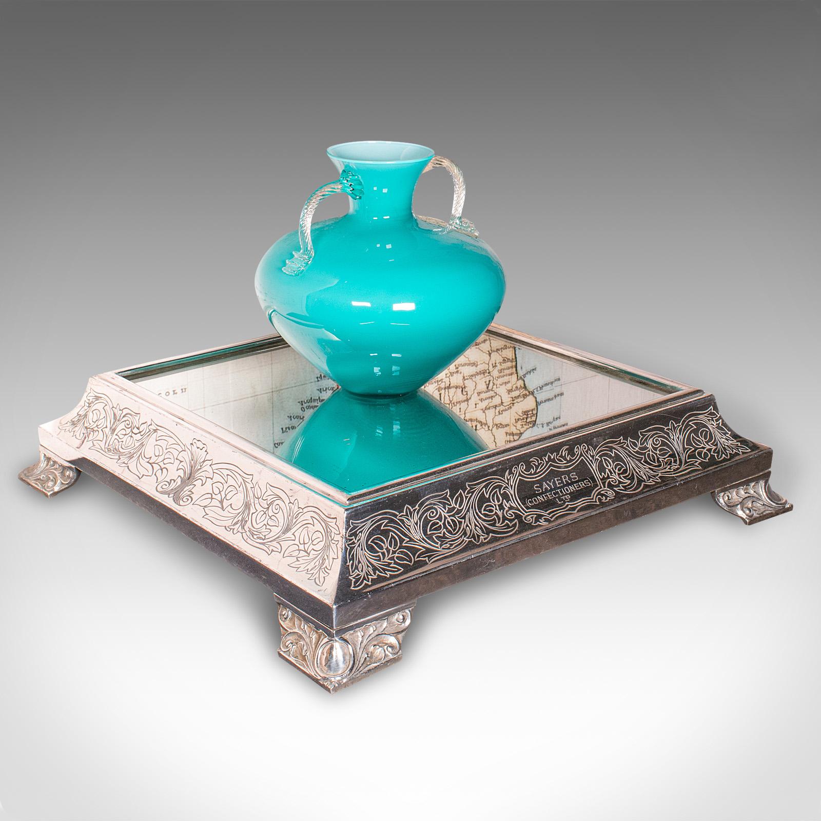 Se trata de un expositor de tartas vintage con espejo. Soporte de presentación inglés, plateado, para tiendas o bodas, de principios del siglo XX, hacia 1930.

Tonalidad magnífica y aspecto brillante de este fino soporte personalizado
Presenta una