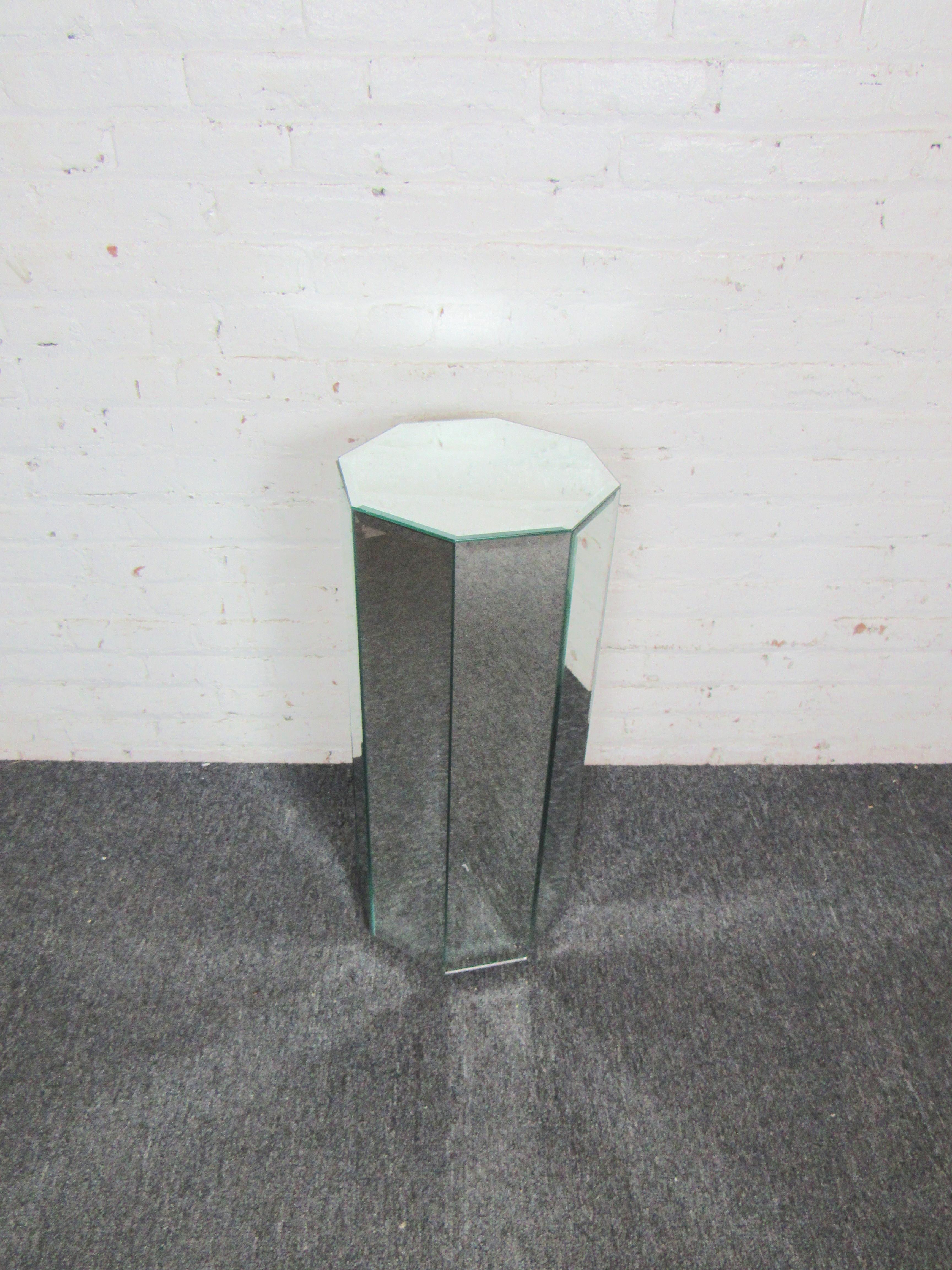 An interesting eight-sided pedestal covered in mirror panels, this vintage piece adds elegant Mid-Century style to any space. Please confirm item location with seller (NY/NJ).