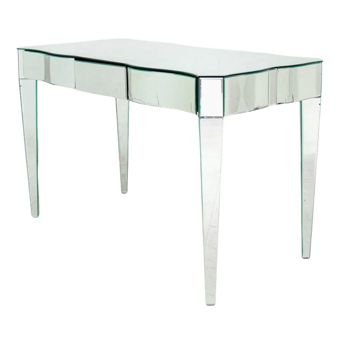 Table de toilette ou bureau vintage en miroir avec un bord festonné le long du tablier et des pieds effilés.  Trois tiroirs.  Entièrement recouvert d'un miroir.  Quelques taches, usures et dommages sur les panneaux de miroir.