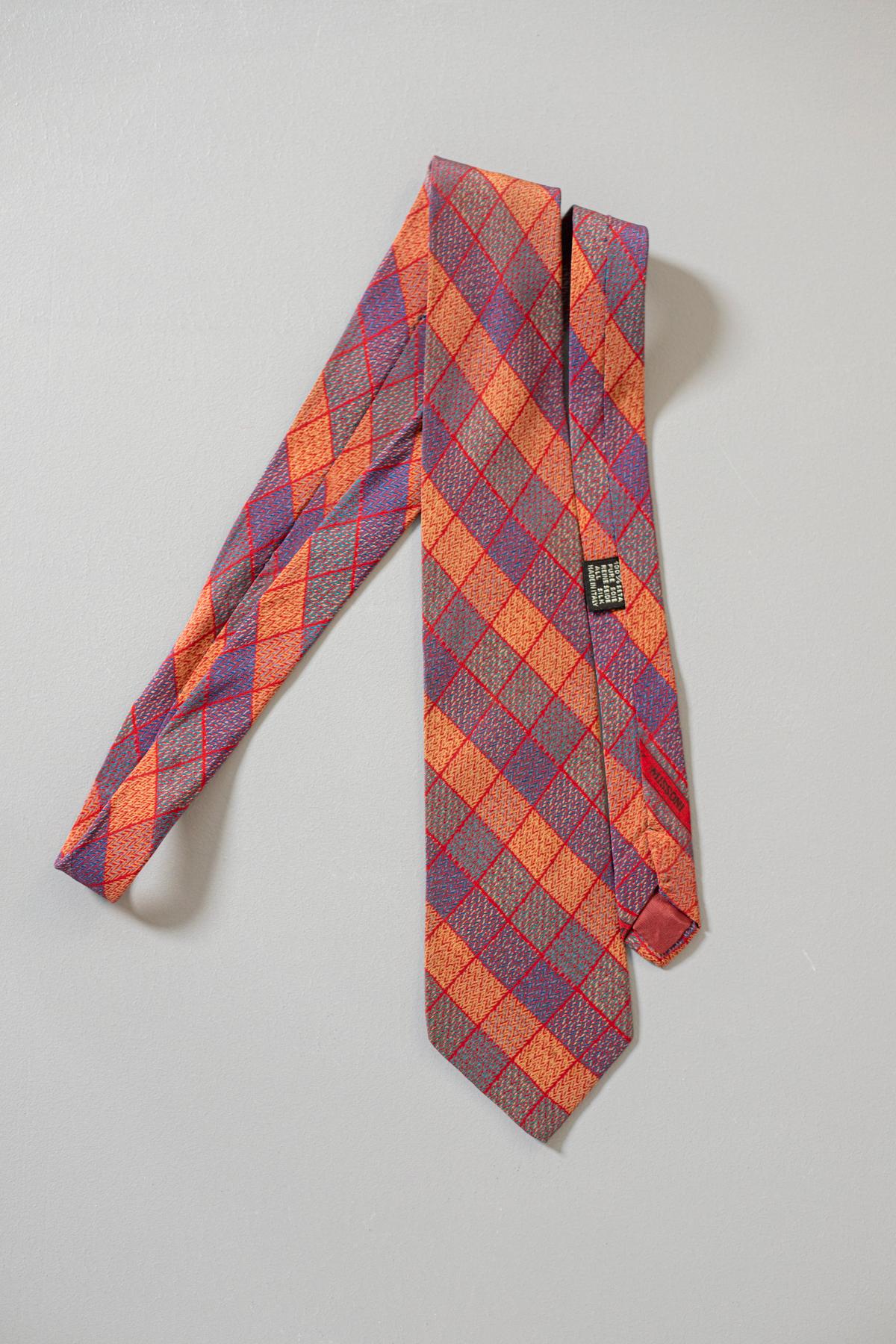 A true evergreen, this tie is timeless. Designed by Missoni, it mirrors the great Italian taste in fashion. This all-silk vintage tie is colourful, yet classical. Decorated with orange, purple, and grey rhombuses, it gives a touch of style on a