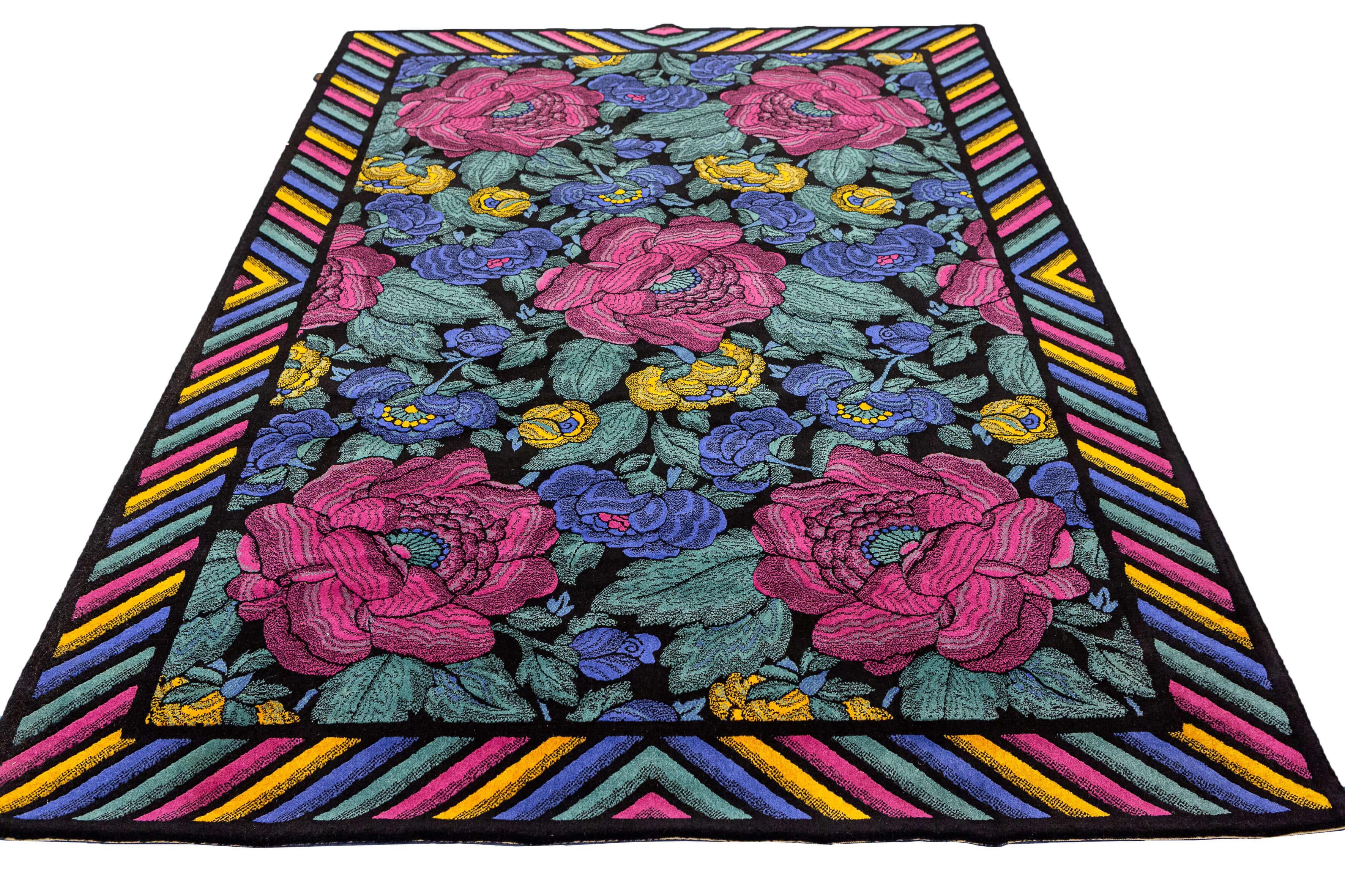 Ce tapis vintage de la marque Missoni est une pièce saisissante et vibrante qui combine des couleurs vives, des motifs floraux à grande échelle et un savoir-faire artisanal impeccable. Avec une bordure multicolore et un champ sombre, ce tapis dégage