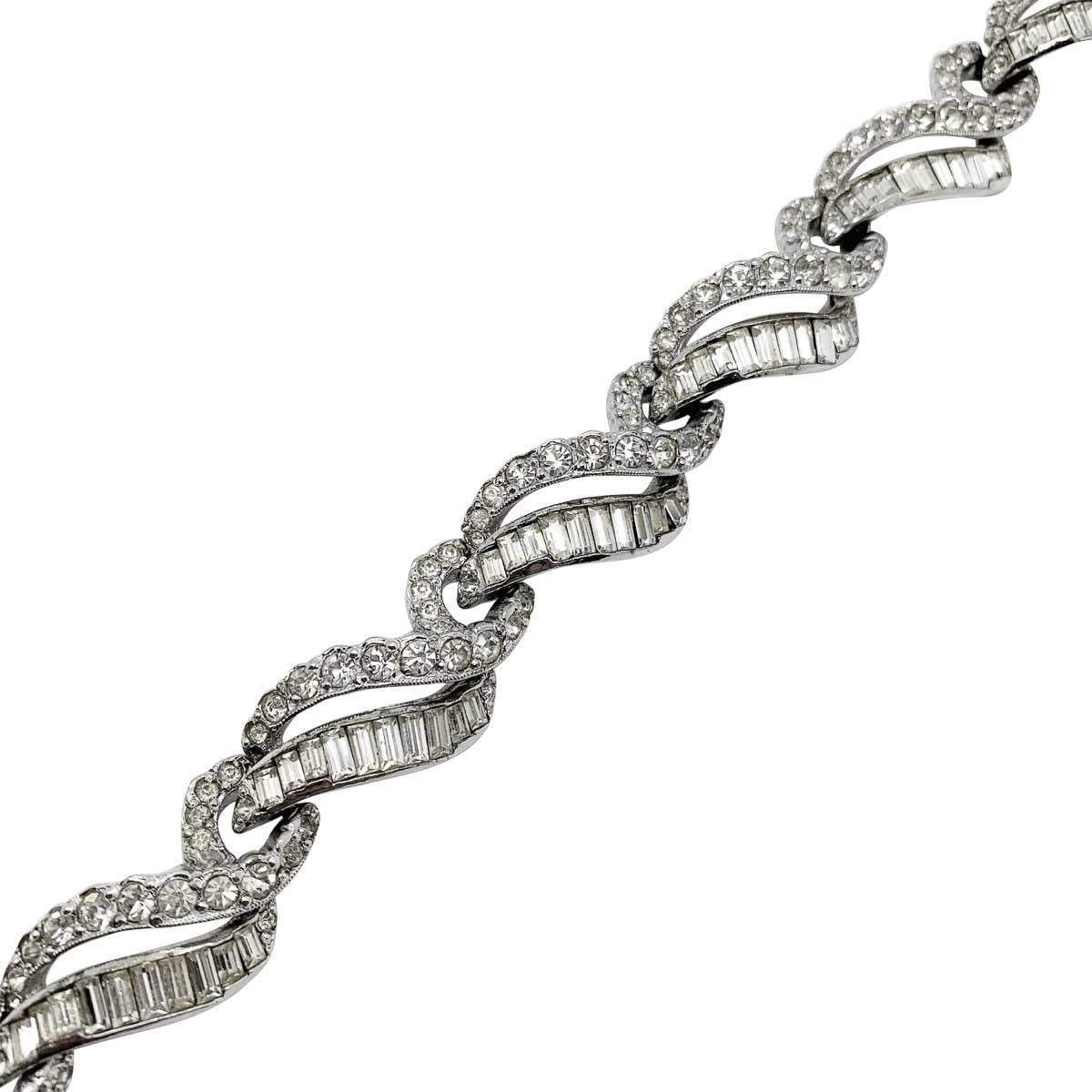 Un rare et magnifique bracelet vintage Mitchel Maer. Ce modèle de style déco est serti de cristaux fantaisie en métal plaqué rhodium. Cet adorable bracelet vintage Mitchel Maer aurait été fabriqué à Londres, en Angleterre, au début des années 1950.