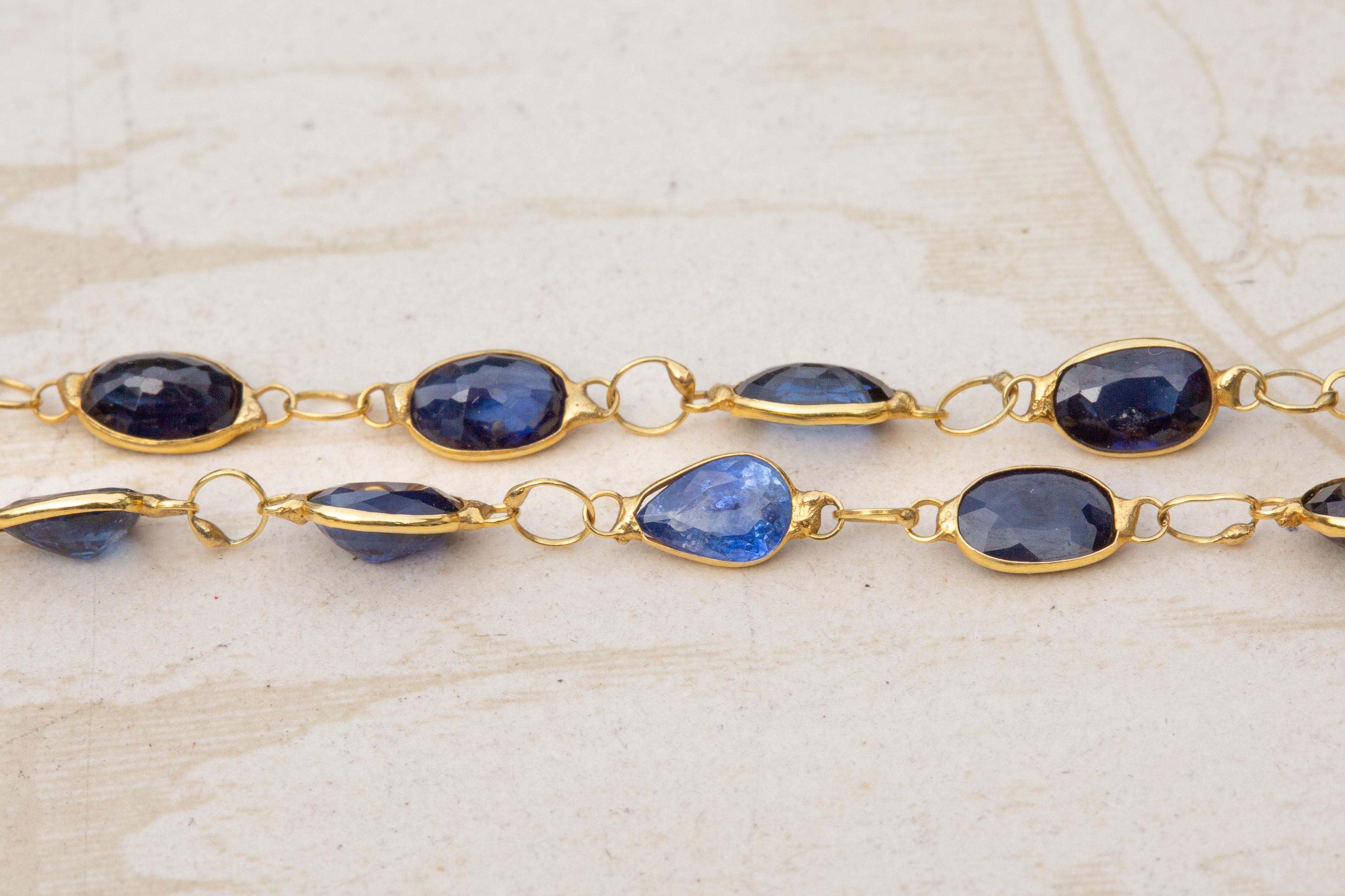 Eine fantastische einsträngige Saphir-Halskette im Vintage-Stil. Die ovalen Saphire im Mischschliff sind alle brillenförmig gefasst und durch ouroborosförmige Sprungringe verbunden. Der Ouroboros ist ein antikes Symbol für eine Schlange, die ihren