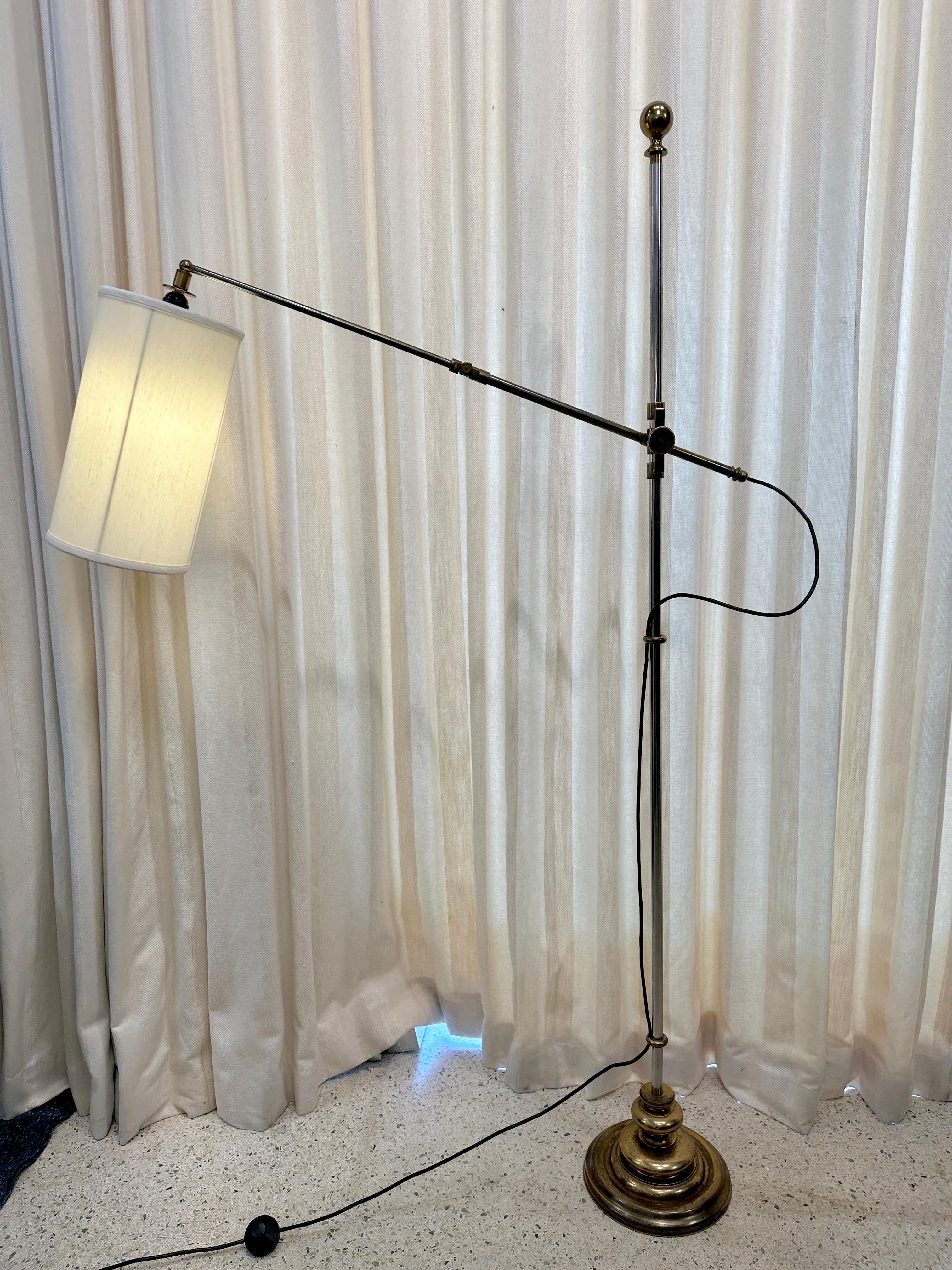 Exceptional brass and steel floor lamp from Italy.  Details abound with brass rings to stem/ body of lamp, as well as original brass ball finial. The arm extends quite far if you need, as well as the arm raises up or down in height level.  The