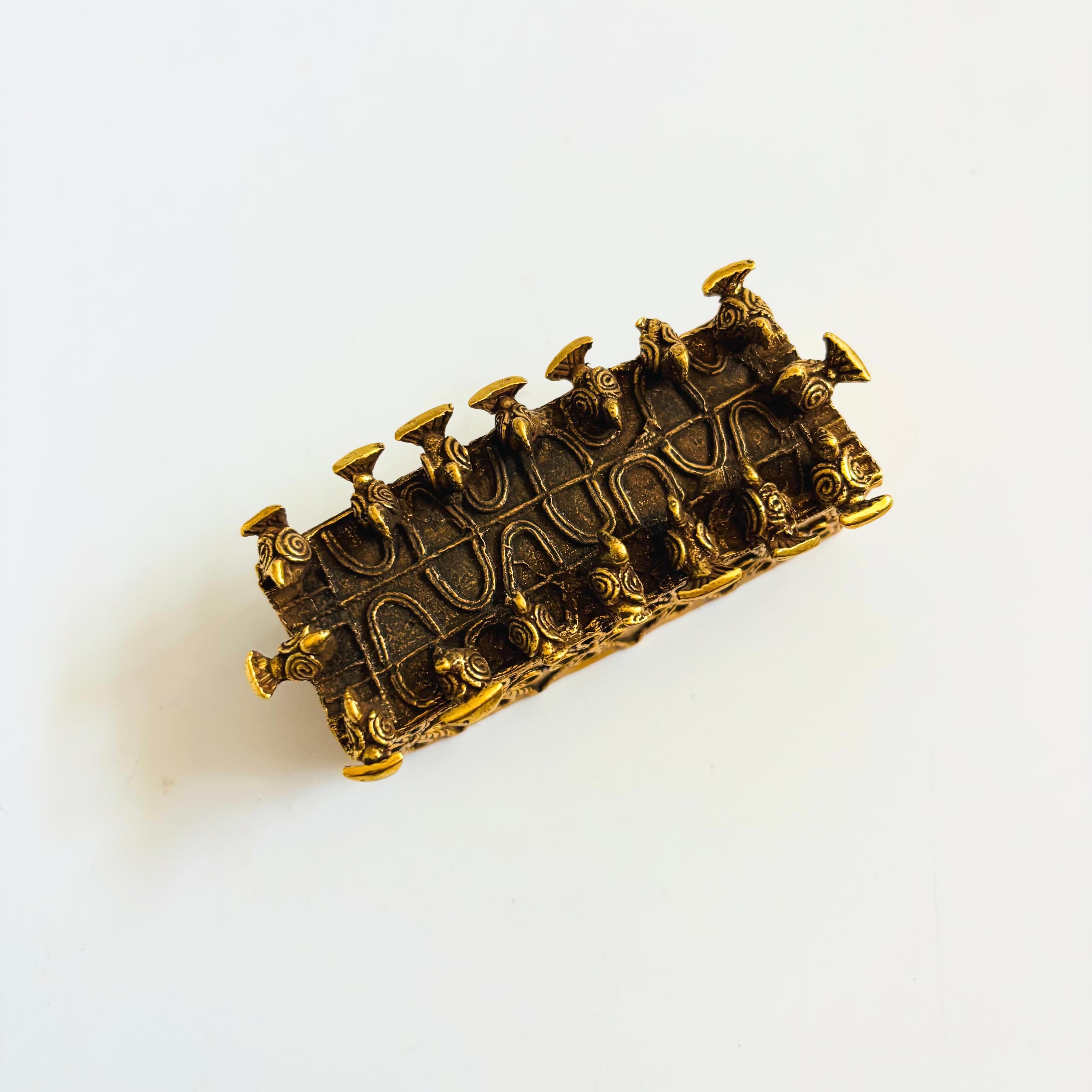 Riproduzione d'epoca del 1989 del Museum of Modern Art di una scatola di polvere d'oro Asante. Realizzato in metallo dorato con un bellissimo disegno di uccelli appollaiati lungo i bordi del coperchio. Alcuni uccelli hanno la coda lunga e altri la