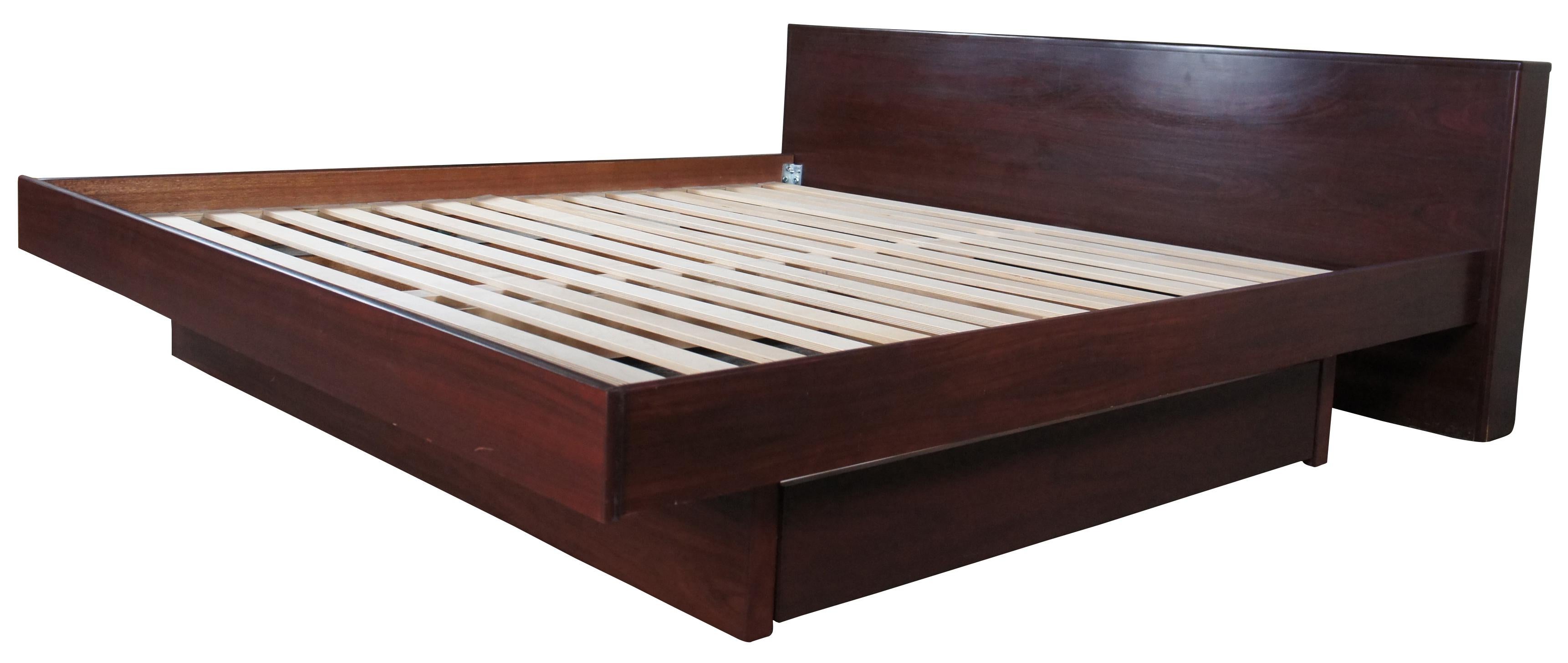 Vintage Mobican Danish Modern King size floating bed with under storage. Made from Rosewood with with a sleac design featuring pull out drawers for garmants along the left and rid side. 

Mobican is a Canadian luxury furniture manufacturer. They