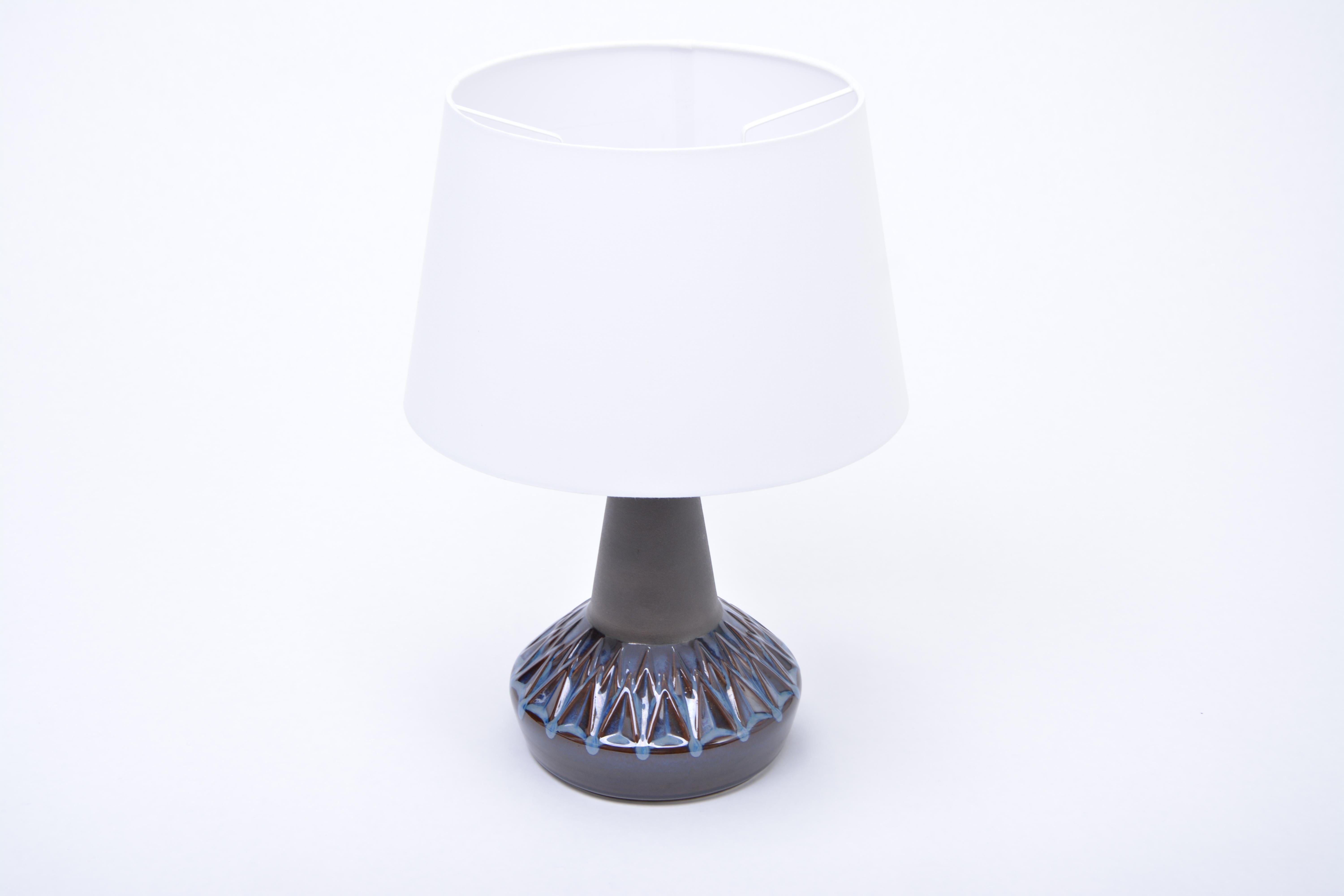 Mid-Century Modern table lamp model 1058 by Soholm

Stoneware table lamp with geometric pattern to its base produced in Denmark by Soholm. Beautiful ceramic glazing in tones of blue. The lamp has been rewired for European use and has a new shade. To