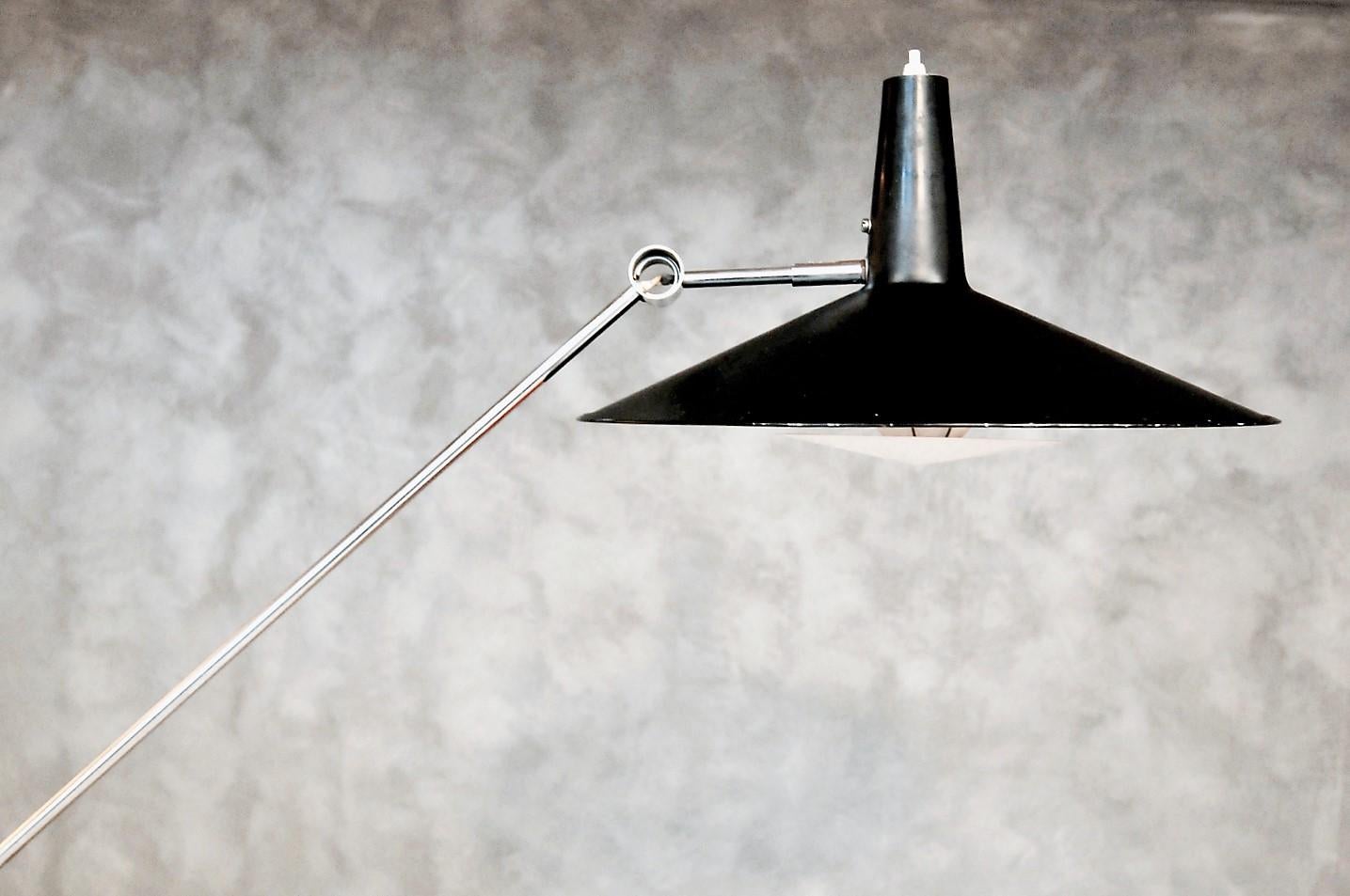 This very rare model 600 lamp, also known as Chinese hat, is equipped with a counterweight system. The lamp can be adjusted into different positions. The metal screen is painted black, while the reflector and base are painted white which is unusual