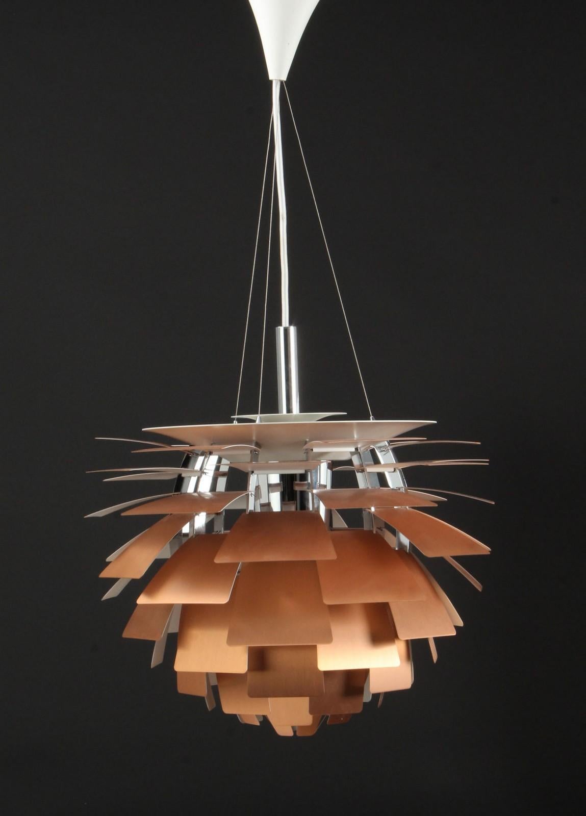 PH artichoke pendant lamp designed by Poul Henningsen for Louis Poulsen, 1950s.
Artichoke', with 72 copper blades placed on 12 chromed steel arcs. Complete with socket cover in chromed aluminum, suspension wire, white fabric cable, and canopy.