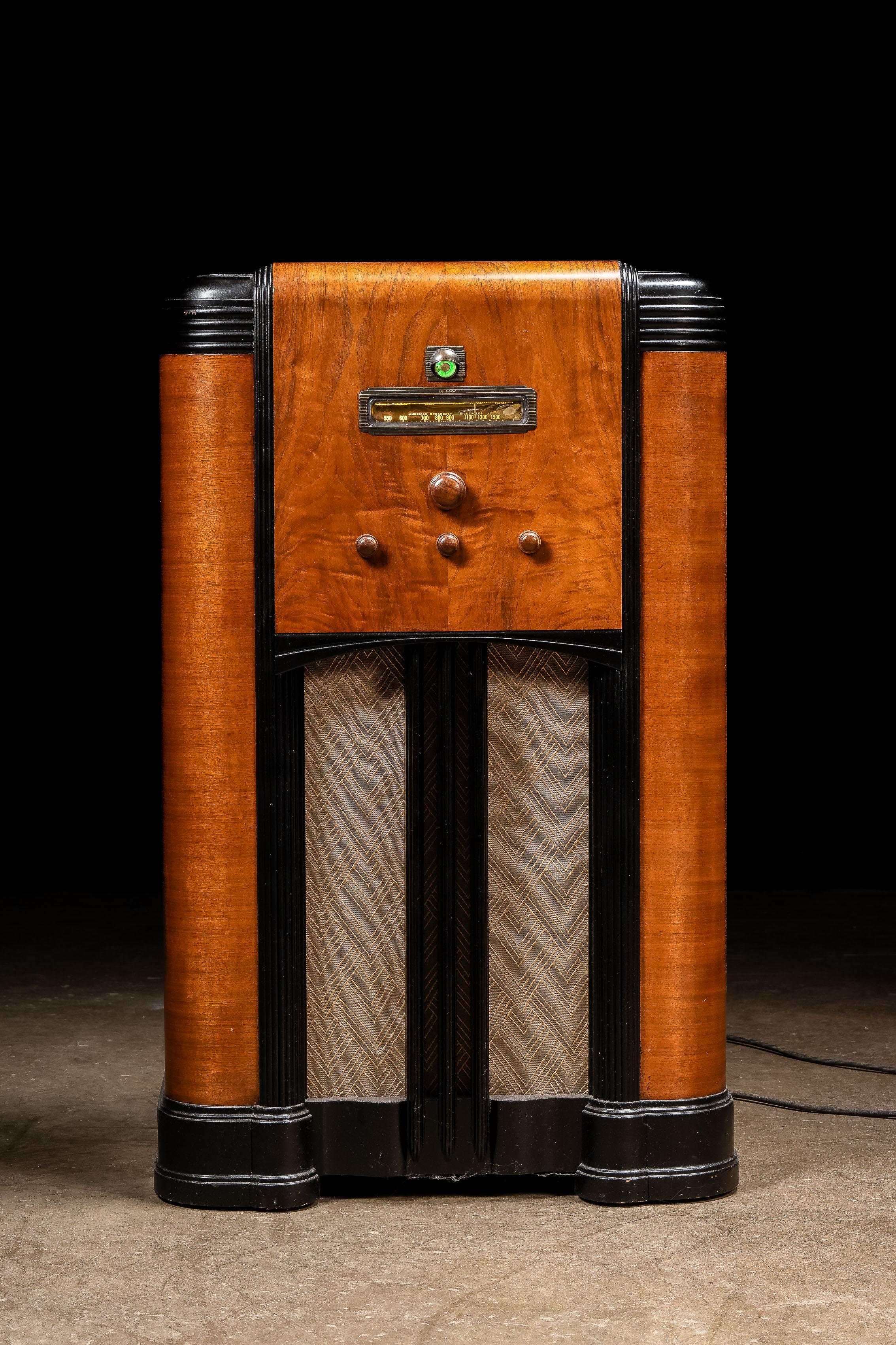 1937 ; United Motors Service - New York

Radio console Art Déco aux lignes épurées, avec boutons de réglage en bois.

Cette pièce est équipée d'un tube Magic Eye à l'état solide, un moyen peu coûteux de faire le même travail que les compteurs à