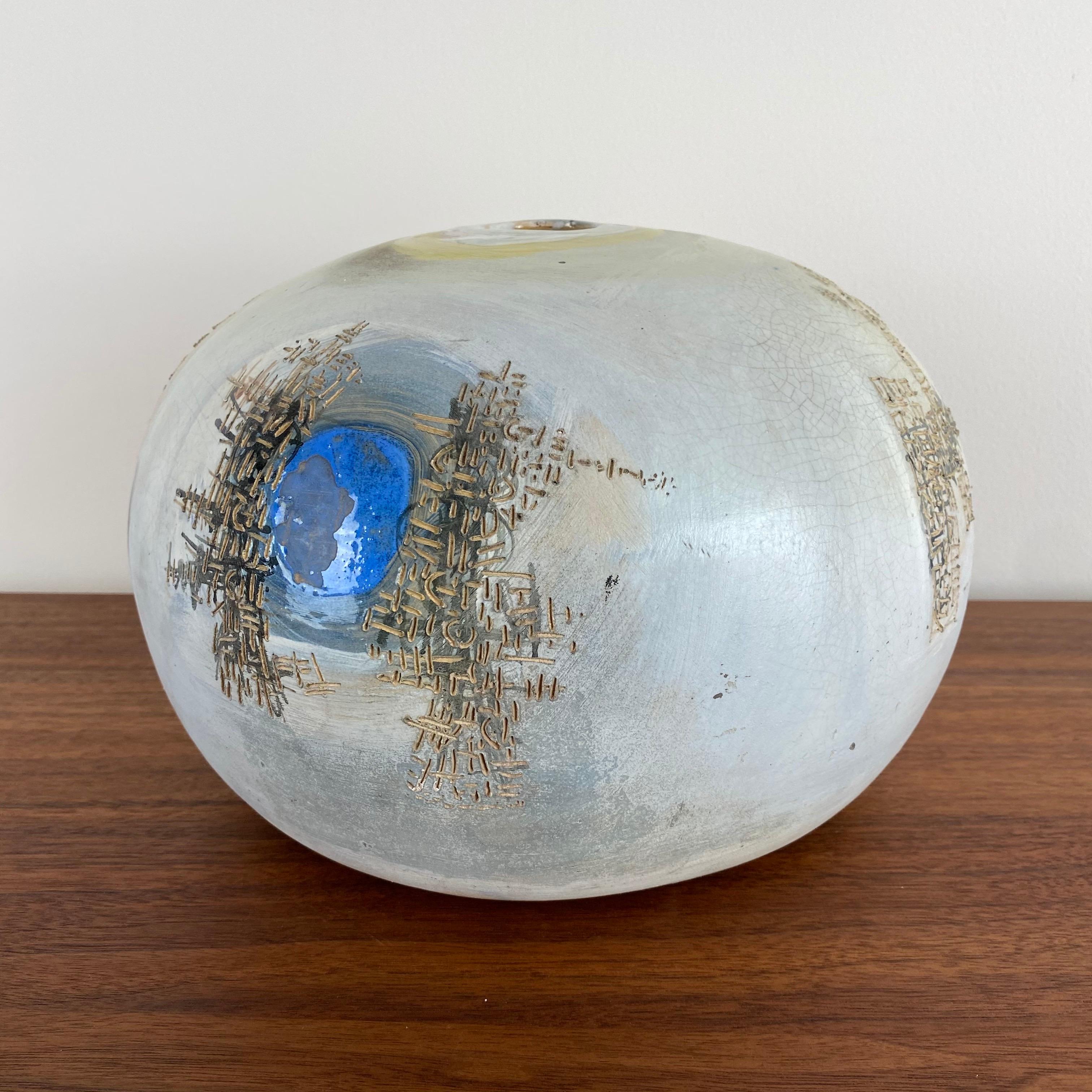 This bulbous vase has a soft blue glaze with abstract designs around the body. Multi-colored with texture and movement.