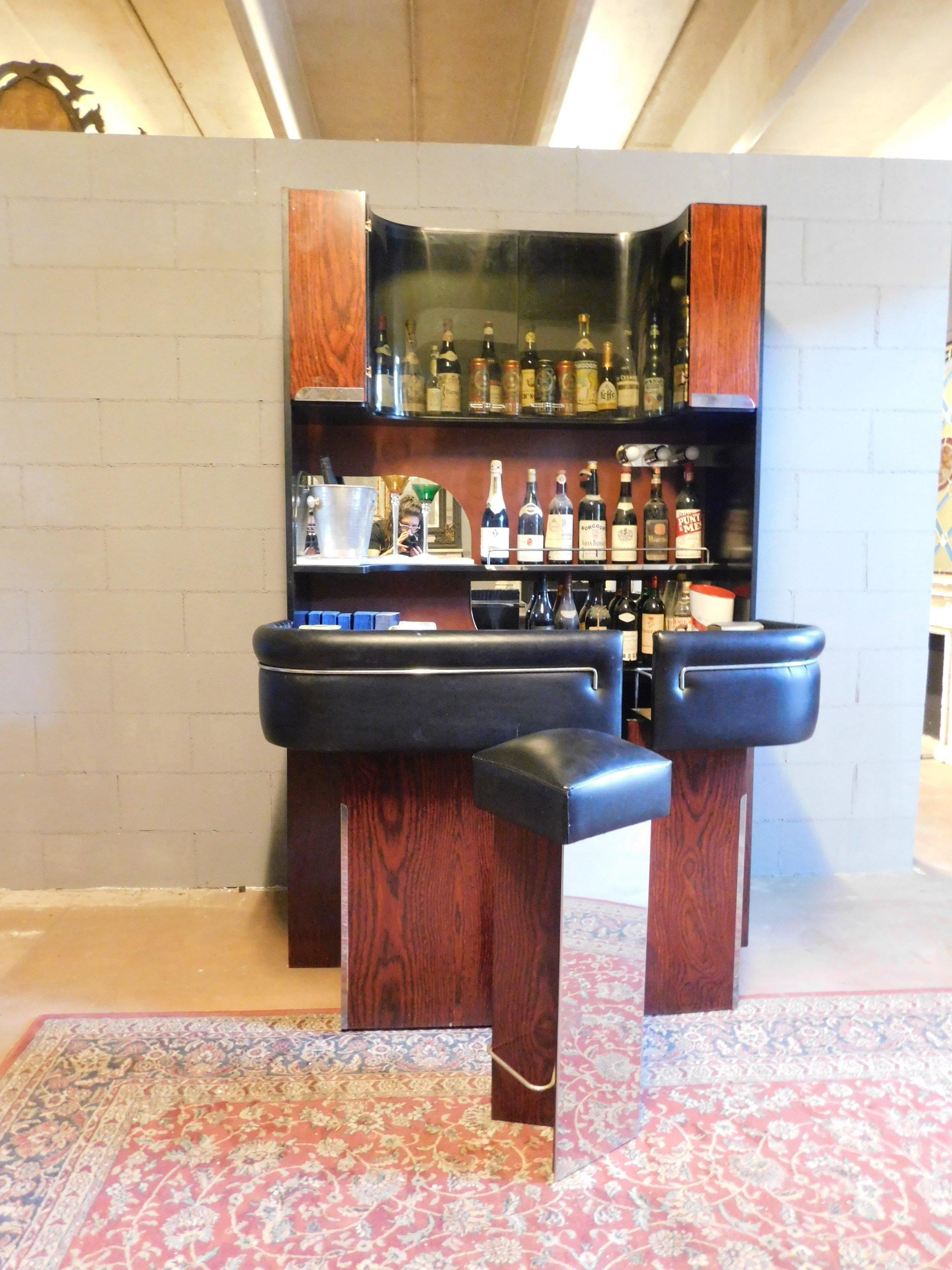 Vintage modern antiques bar cabinet with counter that opens halfway to accommodate the bartender, and original stool with mirrors and black leather, produced by an Italian company in the fabulous, 1980s.
In perfect condition, to check the lights,
