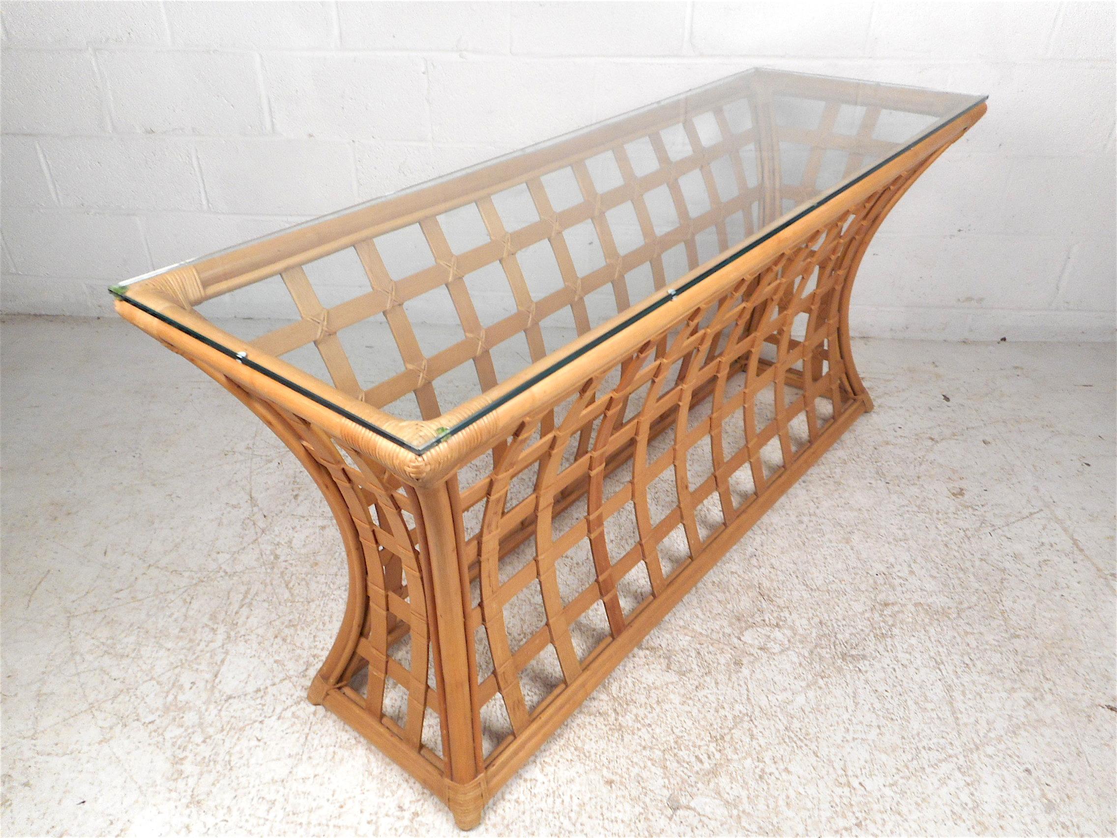 Unique vintage modern bamboo and glass console table. Base features an interesting hourglass contour, giving the piece a striking visual profile. A pane of 3/8th in. glass with beveled edges serves as the tabletop. An impressive addition to any