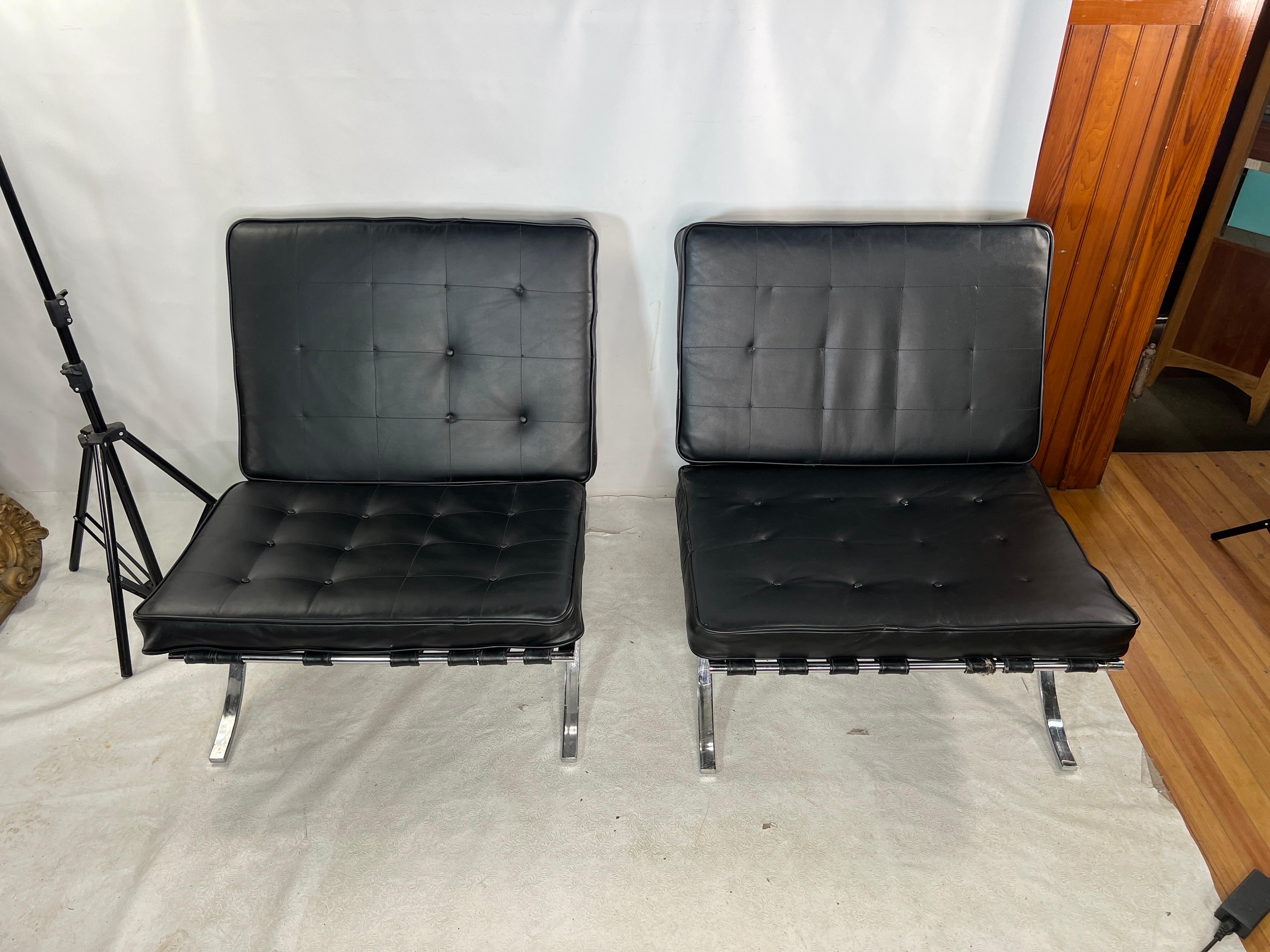 This nice pair of lounge chairs that are made by Selig. The chair cushions are leather and are missing buttons.