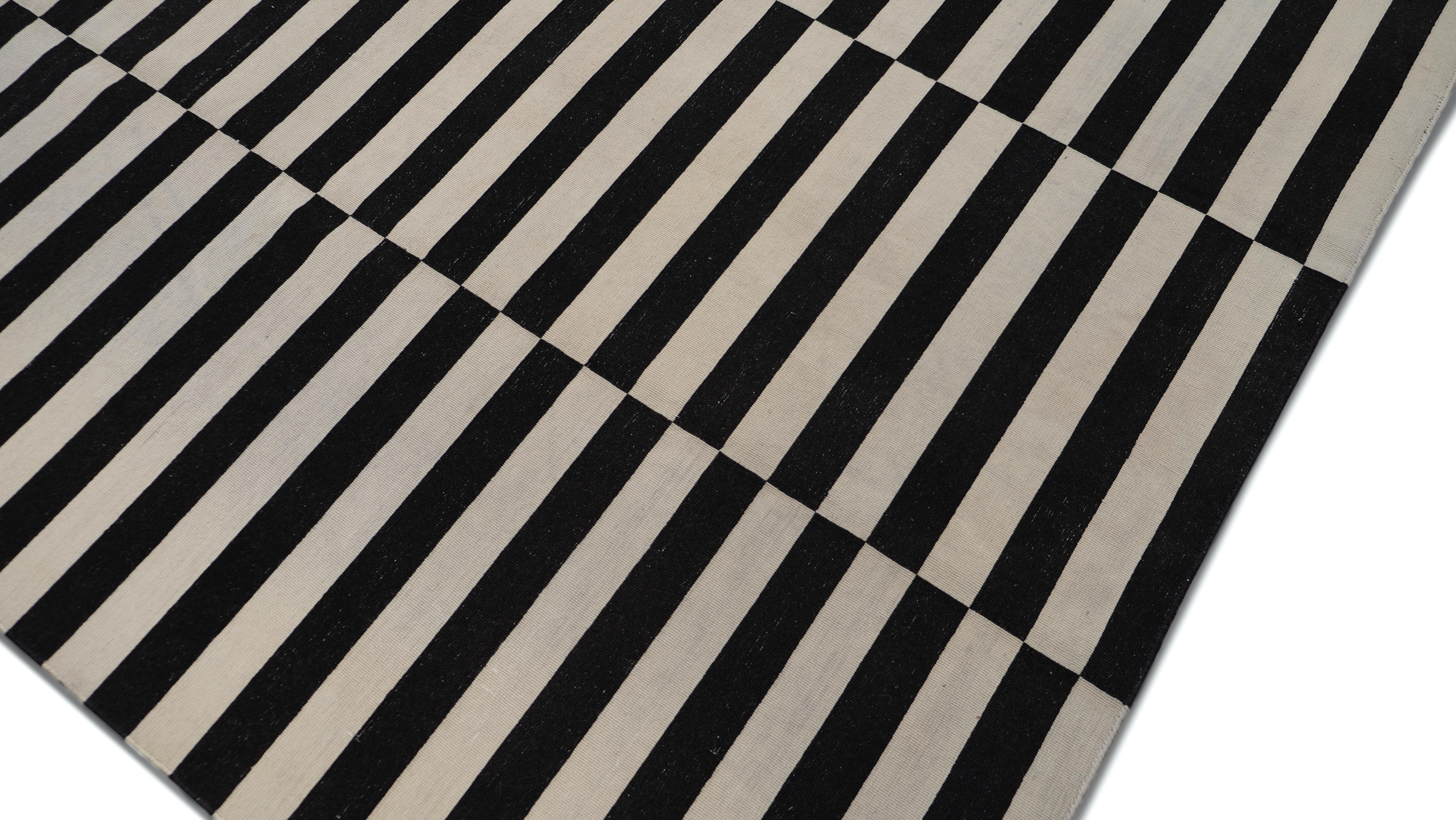 This handwoven wool kilim is a bold, graphic statement piece featuring a striking black and beige striped pattern arranged in an alternating checkerboard effect. It a perfect rug for modern, contemporary, and minimalist interiors.

Handcrafted by