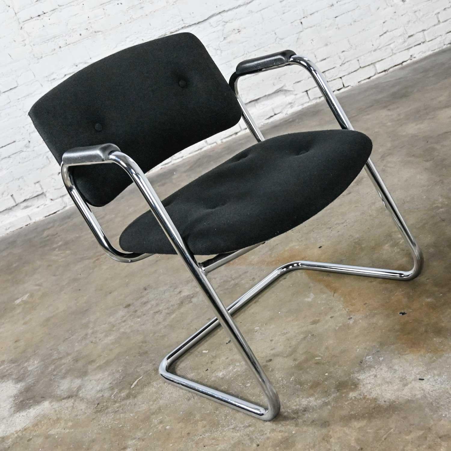 Handsome vintage modern black & chrome cantilever chair by United Chair Company in the style of Steelcase. Comprised of a chrome cantilever frame, black plastic armrests, and its original black hopsacking fabric with button details. Beautiful