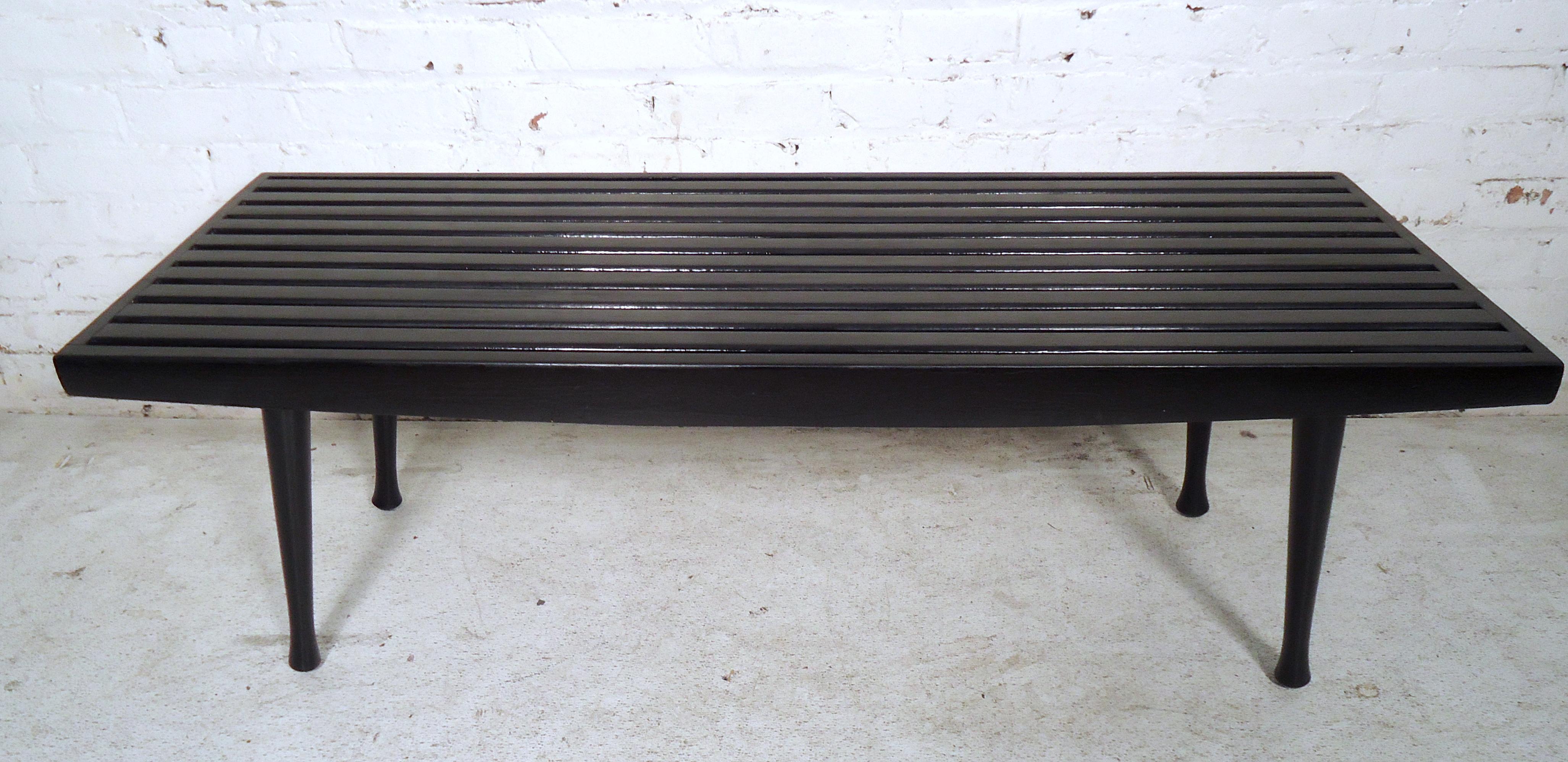Mid-Century Modern black lacquered slat bench featuring tapered legs.
This bench can also be used as a coffee table, would make a great addition to any home or office.

 (Please confirm item location, NY or NJ, with dealer).