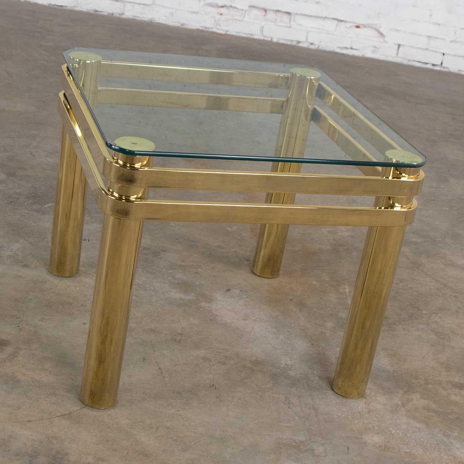 Handsome modern design somewhat Hollywood Regency style brass and glass side table or end table similar to pieces by Pace or Karl Springer. It is in wonderful vintage condition. There are some signs of age on the brass. Please see photos, circa