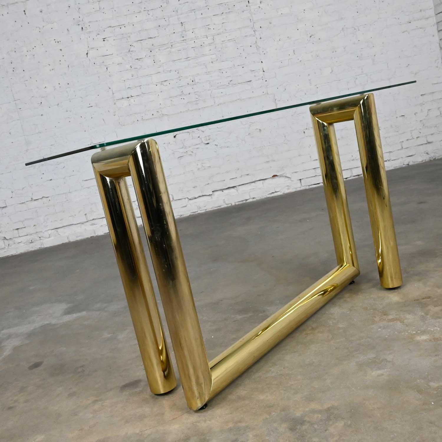 Gorgeous vintage modern brass plated console or sofa table with rectangular glass top in the style of Karl Springer. Beautiful condition, keeping in mind that this is vintage and not new so will have signs of use and wear. There are 3 small chips in