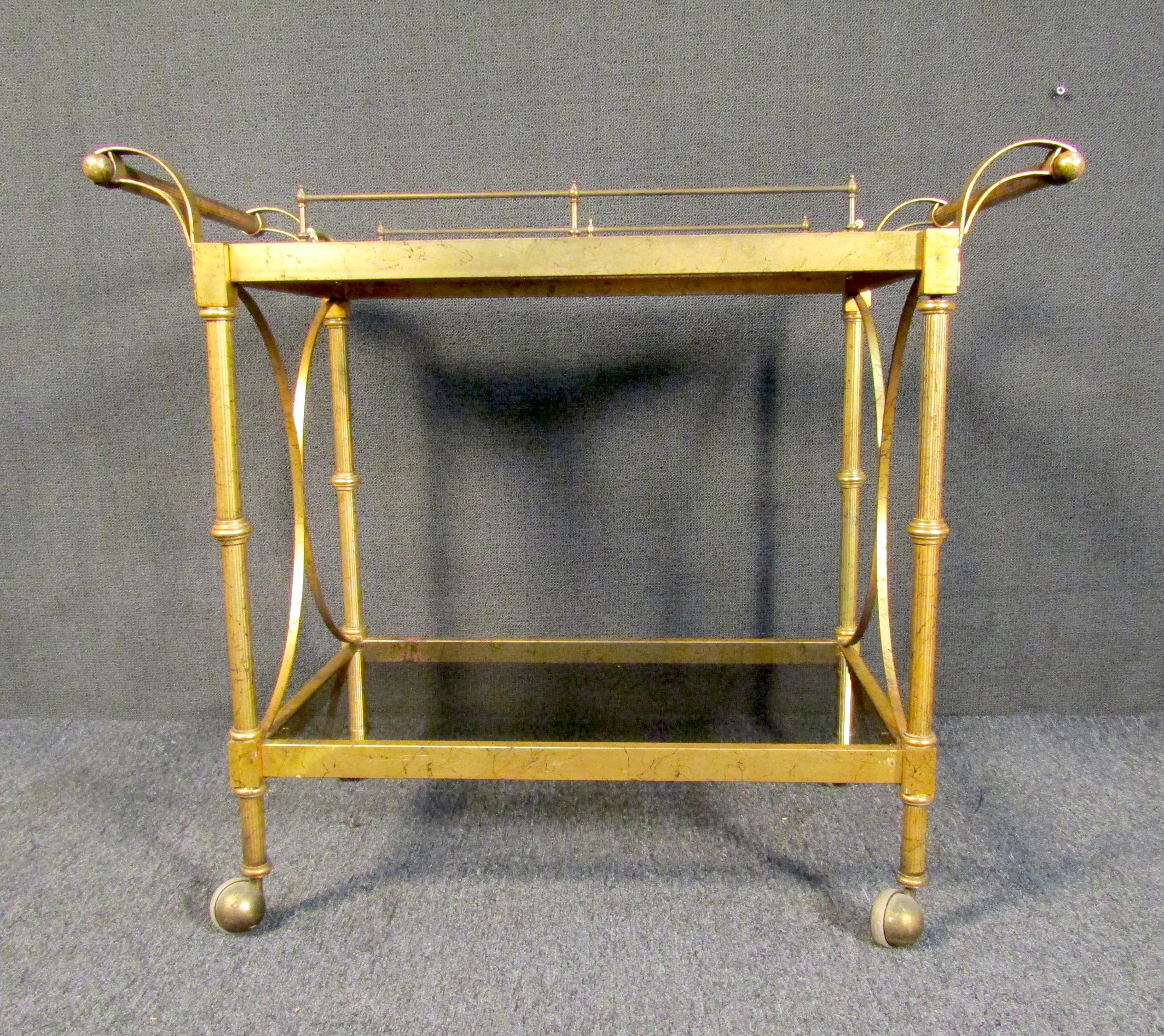 Mid-century modern bar cart in a brass finish. The cart comes with a wooden serving tray that lifts from the top to use for serving guests.

Please confirm the item location with the dealer. (NJ/NY).