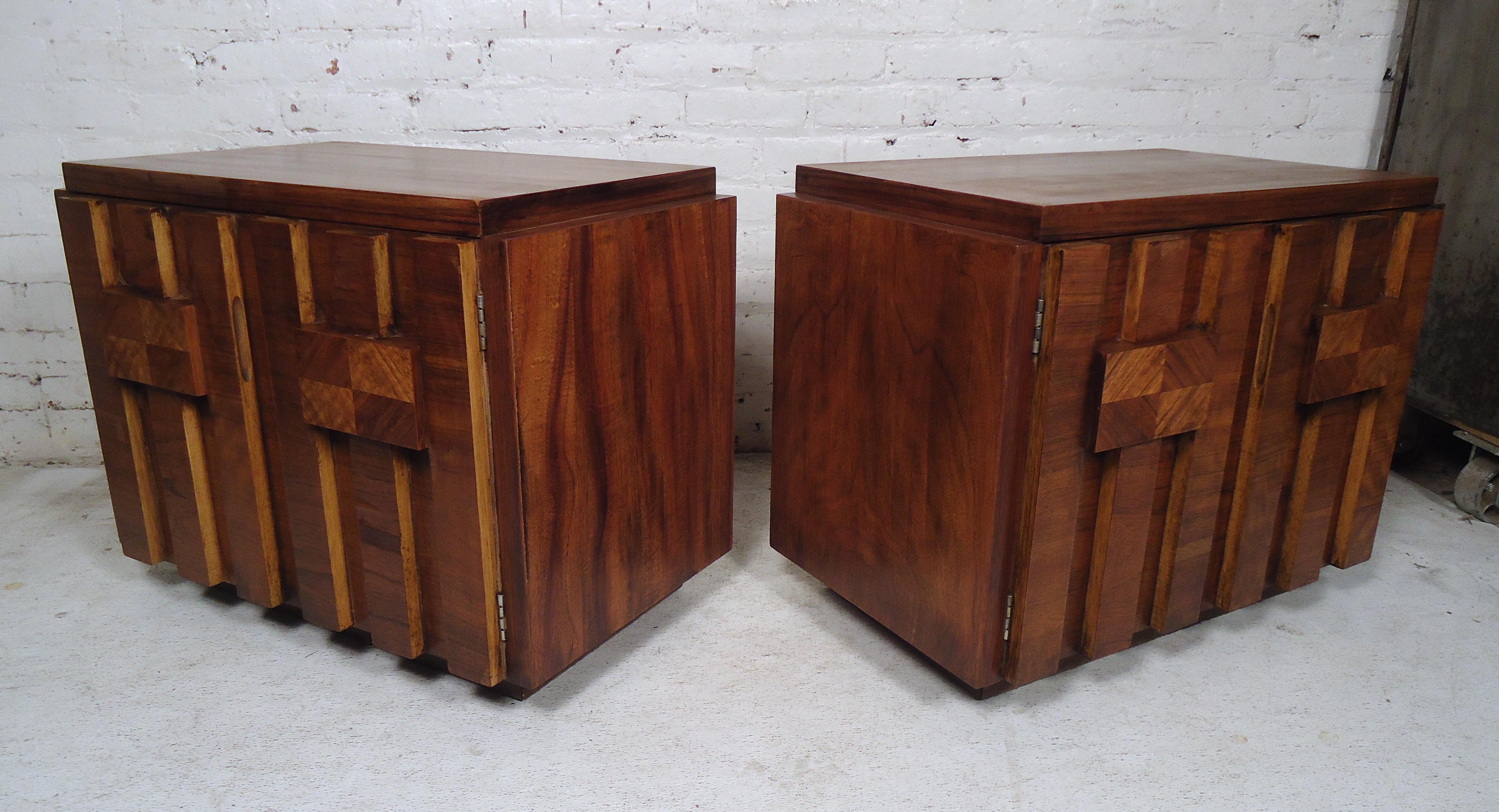 This gorgeous pair of vintage modern nightstands offer plenty of room for storage within its two large compartments and shelves. Quality construction with Brutalist cabinet door fronts. This midcentury case piece has an elegant dark walnut finish
