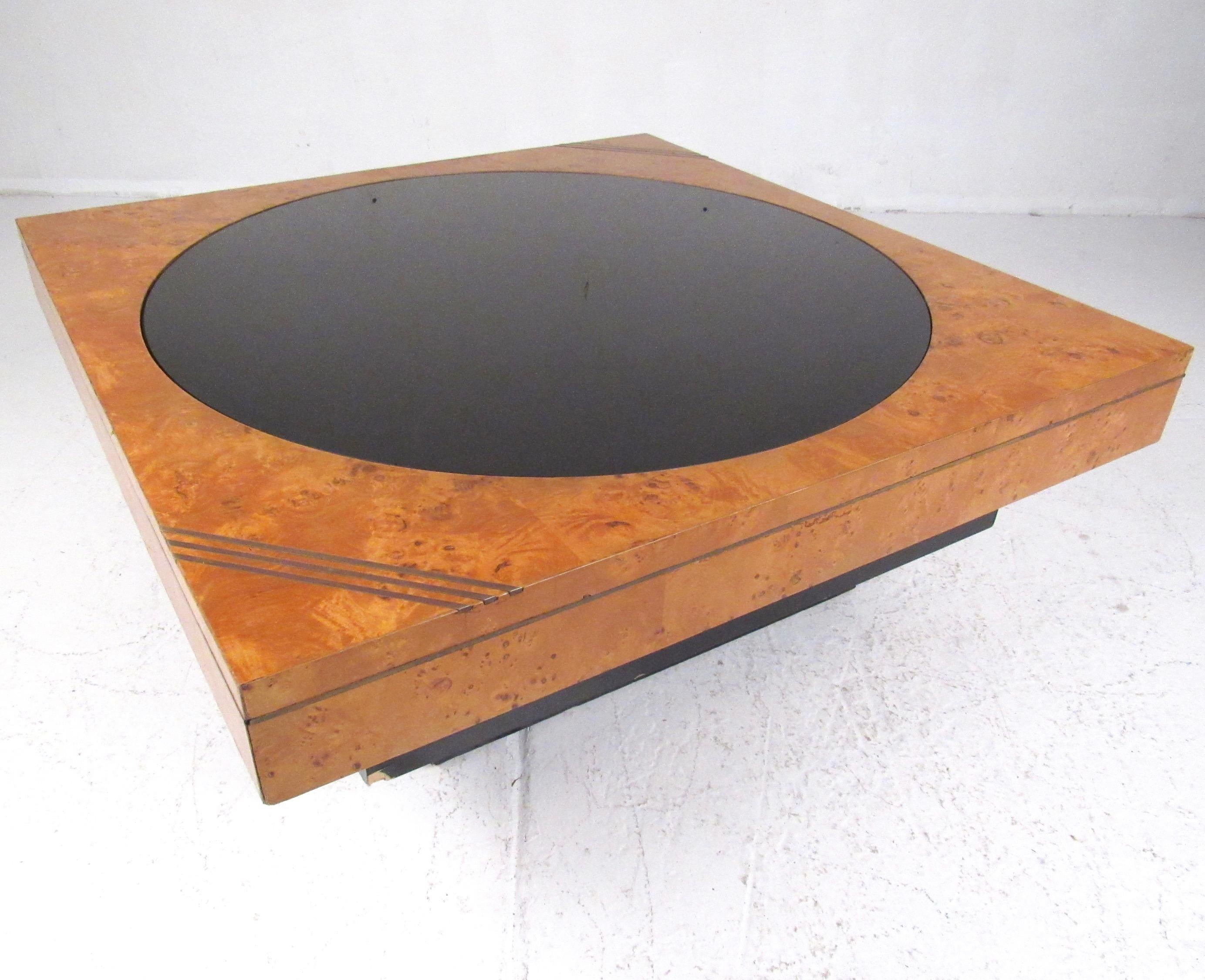 This stylish vintage modern coffee table by Lane features golden burl wood finish with unique brass finish details. Complimentary black lacquer base features elegant down lighting for added decorative affect. Circular dark glass center piece makes