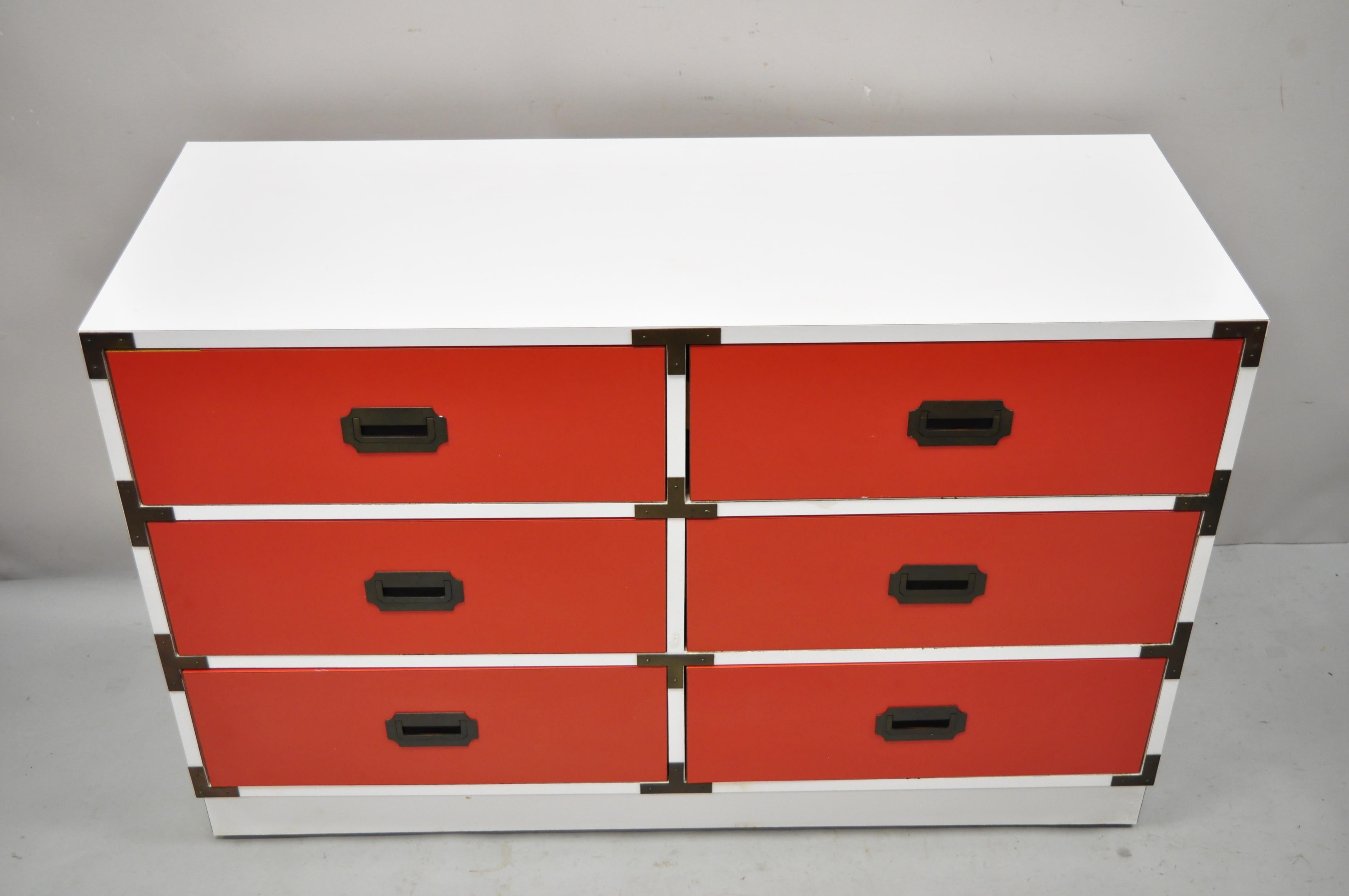 Vintage Modern Campaign style red and white Formica Hollywood Regency dresser chest. Item features formica wrapped case, red formica drawer fronts, inset brass hardware, 6 drawers, very nice vintage item, clean modernist lines, great style and form.