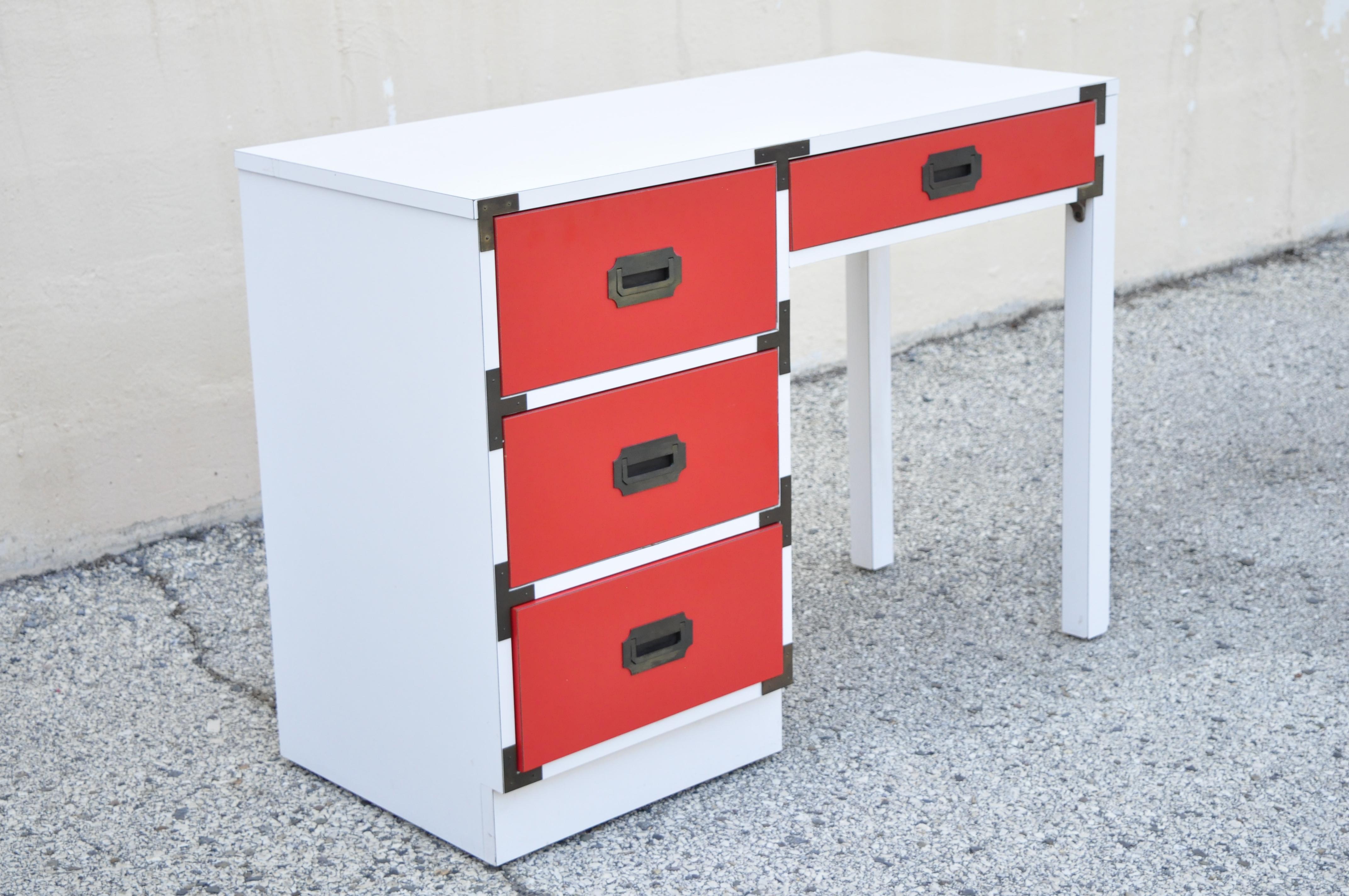 Vintage Modern Campaign style red white Formica Hollywood Regency writing desk. Item features formica wrapped white case, red formica drawer fronts, campaign style drawer pulls, 4 drawers, brass hardware, clean modernist lines, great style and form.