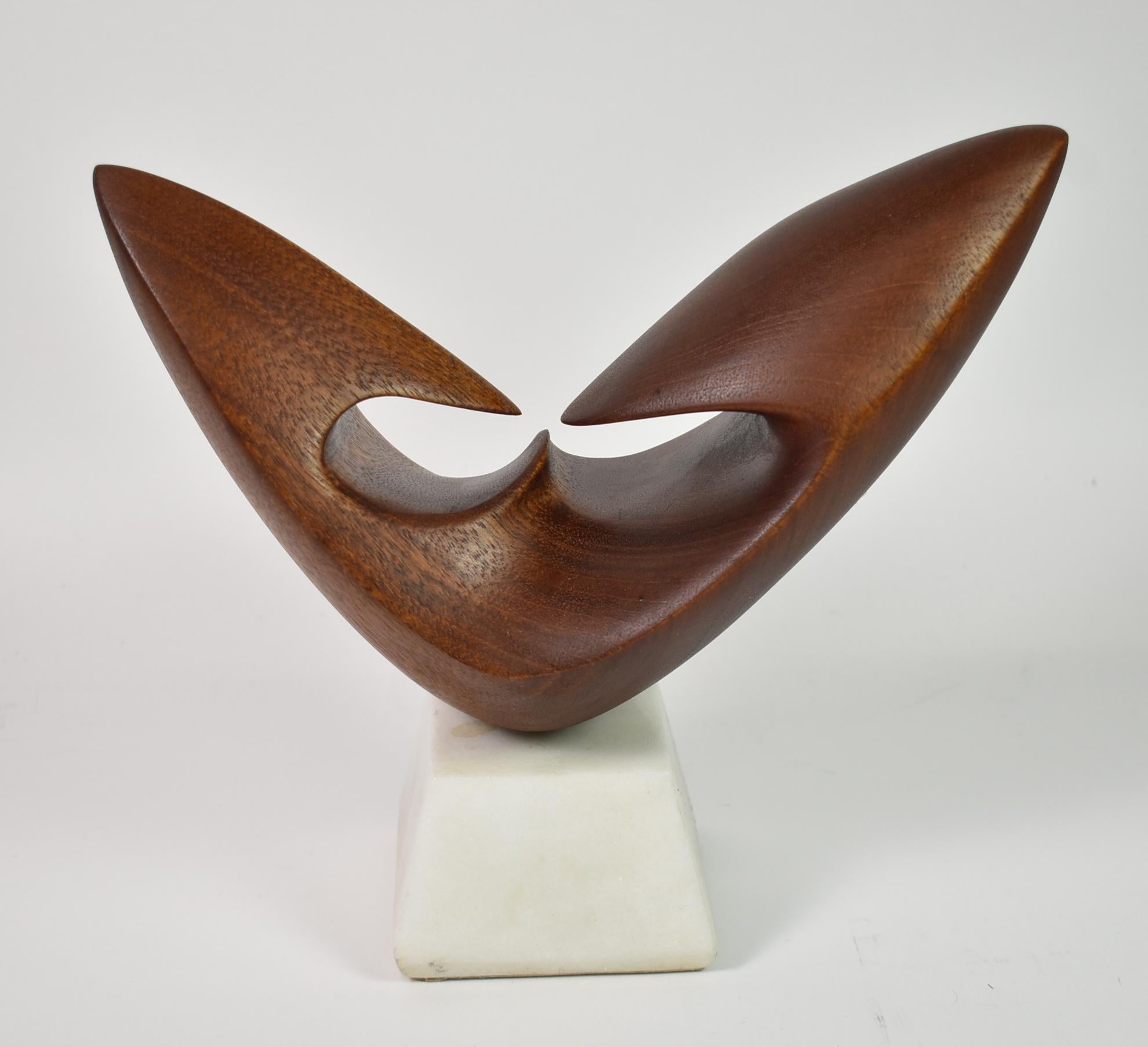 Vintage Modern carved teak sculputre, circa 1960s. Teak smooth abstract form mounted on a white granite base. Appears unmarked. Excellent condition. Base measures: 2.5