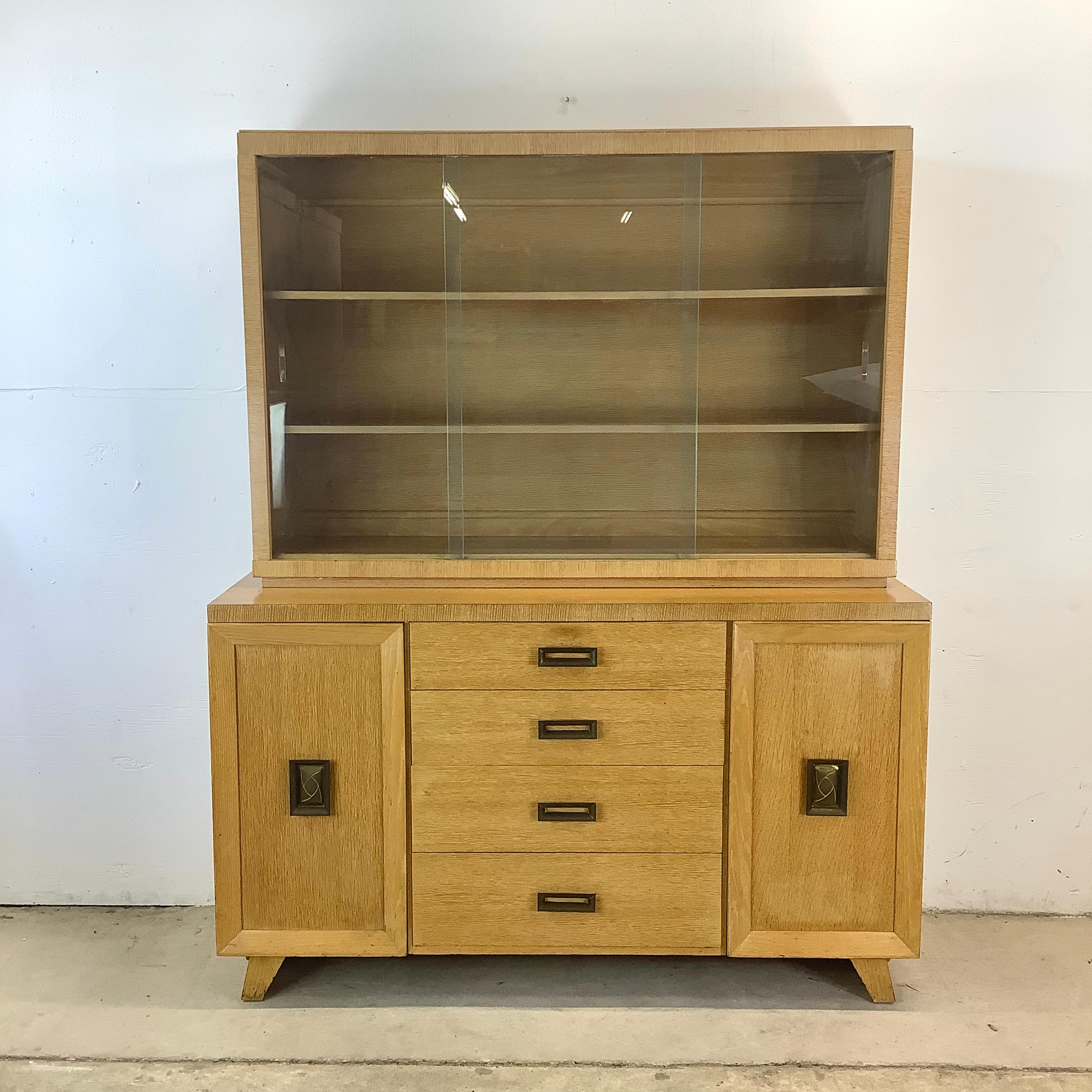 Elevate your interior with this extraordinary two-piece sideboard in the distinctive style of James Mont. With its angular profile, blonde oak finish, and commanding presence, this vintage-inspired cabinet is more than a storage solution—it's a