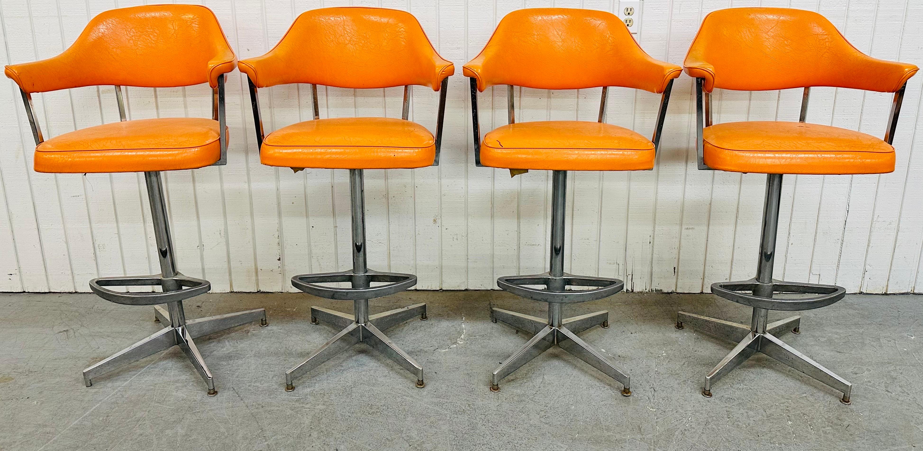 This listing is for a set of four Vintage Modern Chrome Swivel Bar Stools. Featuring an original tangerine leather upholstered back rest and seat, a heavy chrome base with foot rest, and the ability to swivel left or right. This is an exceptional