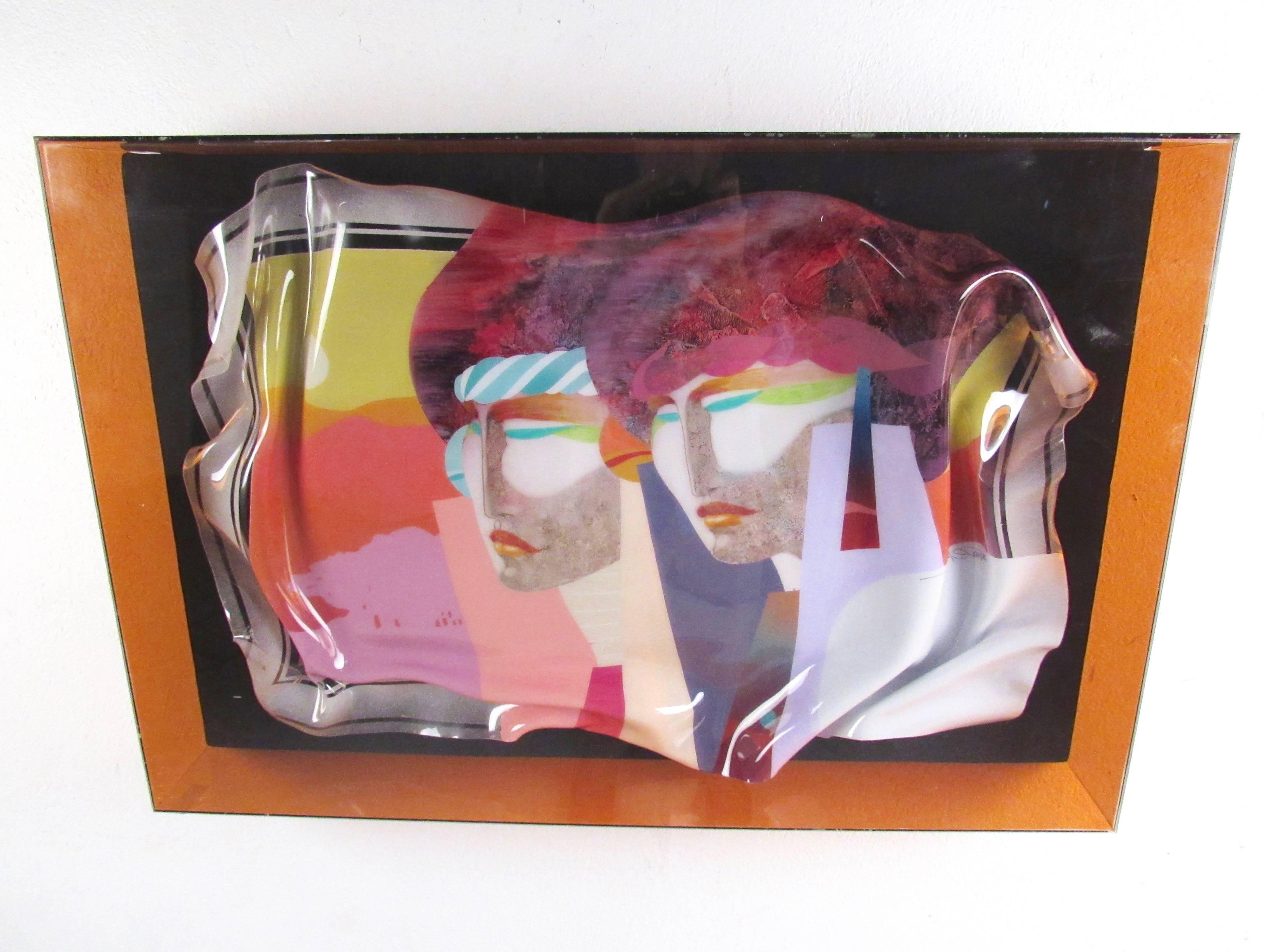 Cet art mural moderne et coloré présente une palette vibrante, représentant deux femmes et une série de motifs abstraits réfléchis. L'art du verre chantourné mélange les couleurs et les formes d'une manière vraiment unique, encadré en toute sécurité