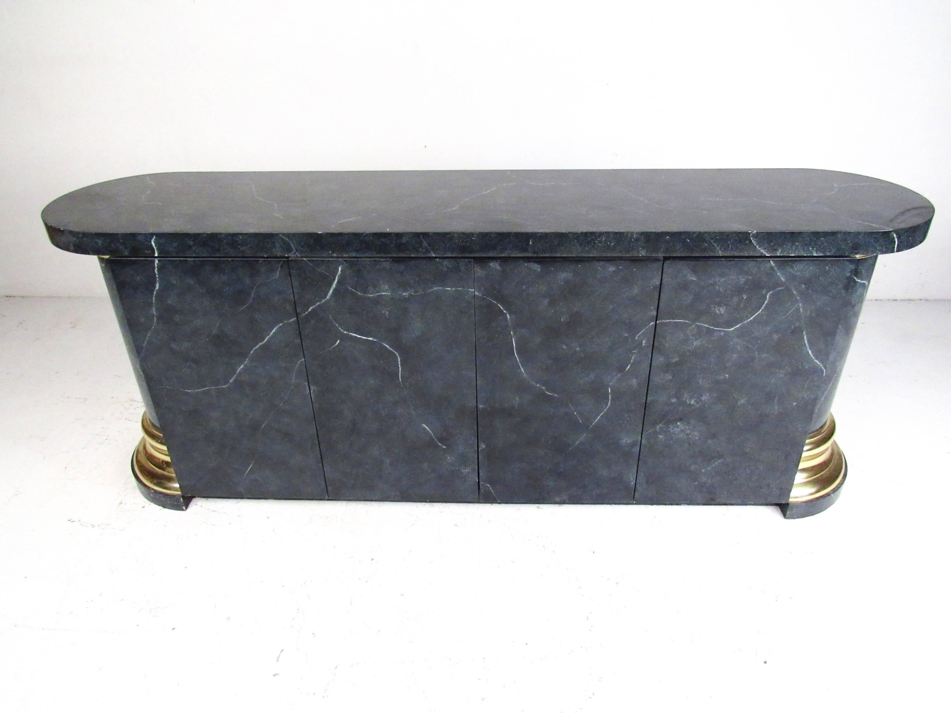 This stylish vintage modern sideboard features deco style design and makes a striking addition to dining room or showroom storage. Faux marbled finish in swirling blue/black palette is complimented by brass plated trim and unique column style sides.