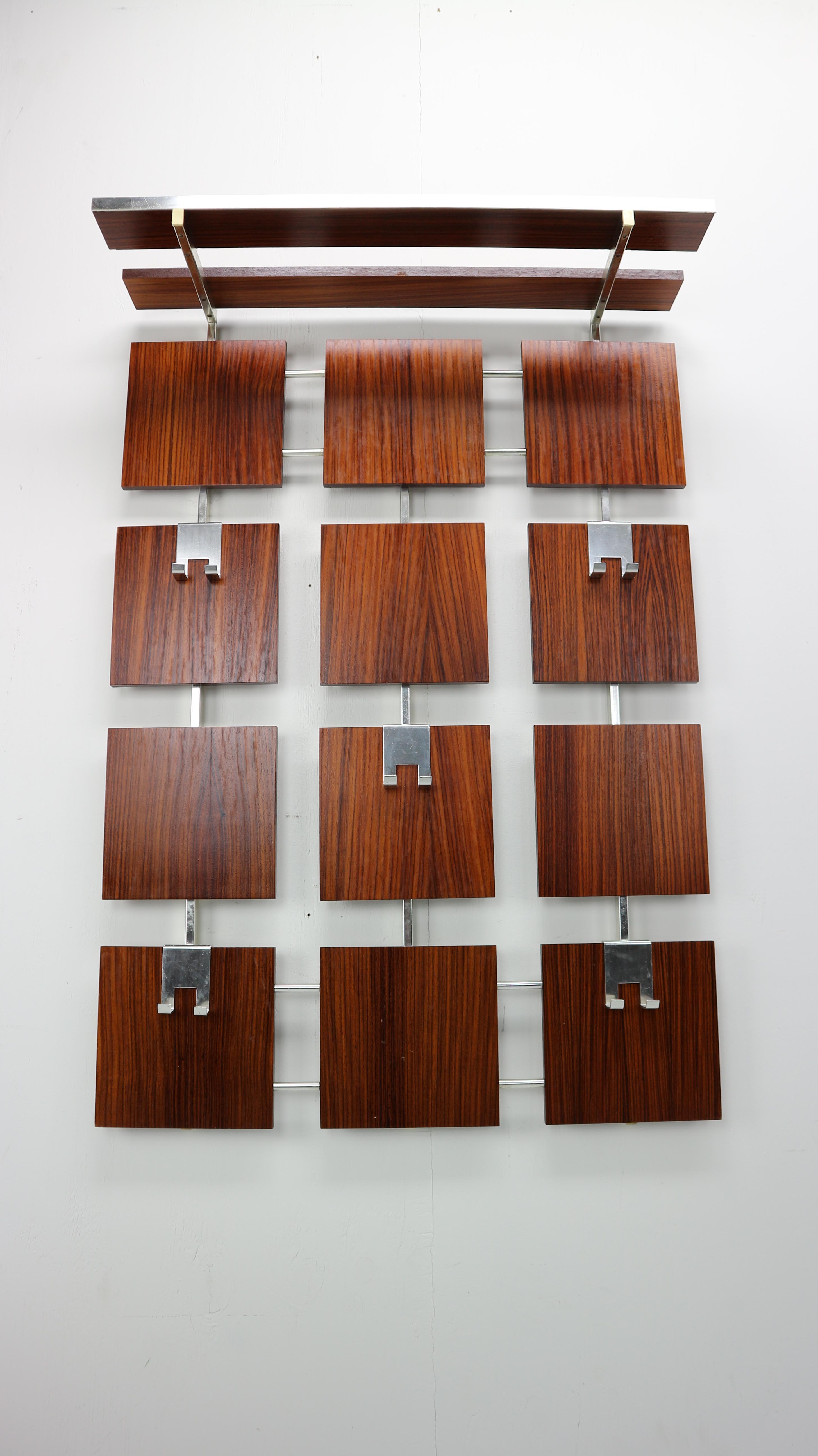 Of the period of Mid-Century Modern design wall-mounted coat and hat rack.

Handsome coat rack consisting of aluminium structure with 12 rectangular pieces of rosewood veneered blocks. The coat rack has a top shelf made of two aluminium brackets