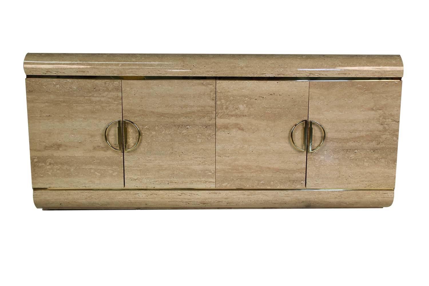 A lovely modernist custom credenza / cabinet circa 1980's, with Classic modern design reminiscent of J. Wade Beam. This exquisite piece features a beautiful faux travertine, laminate, finish with a simple waterfall edge, and modern profile, accented