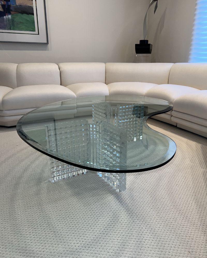 Élevez votre espace de vie avec cette étonnante table basse vintage.

Inspirée par les designs emblématiques d'Adrian Pearsall, cette pièce unique présente un plateau en verre et une base en lucite dans une forme captivante de goutte de larme