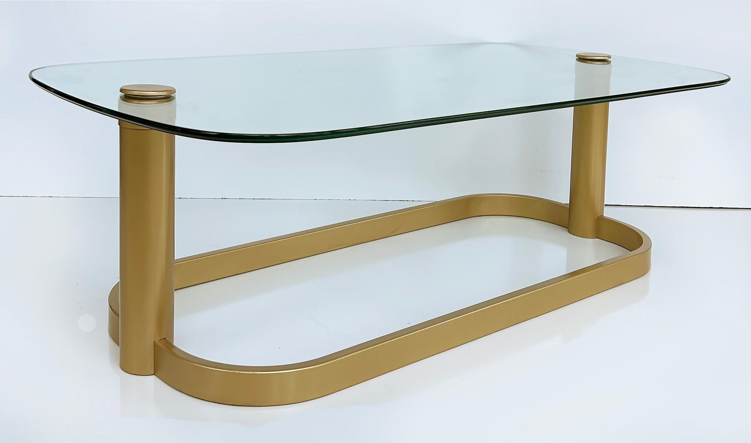 Vintage Modern Glass Top Coffee Table with Metal Base

Offered for sale is a 1980s vintage modern rectangular form glass top coffee table with rounded edges and a metal base. The base is painted gold. The top is secured to the base by matching gold