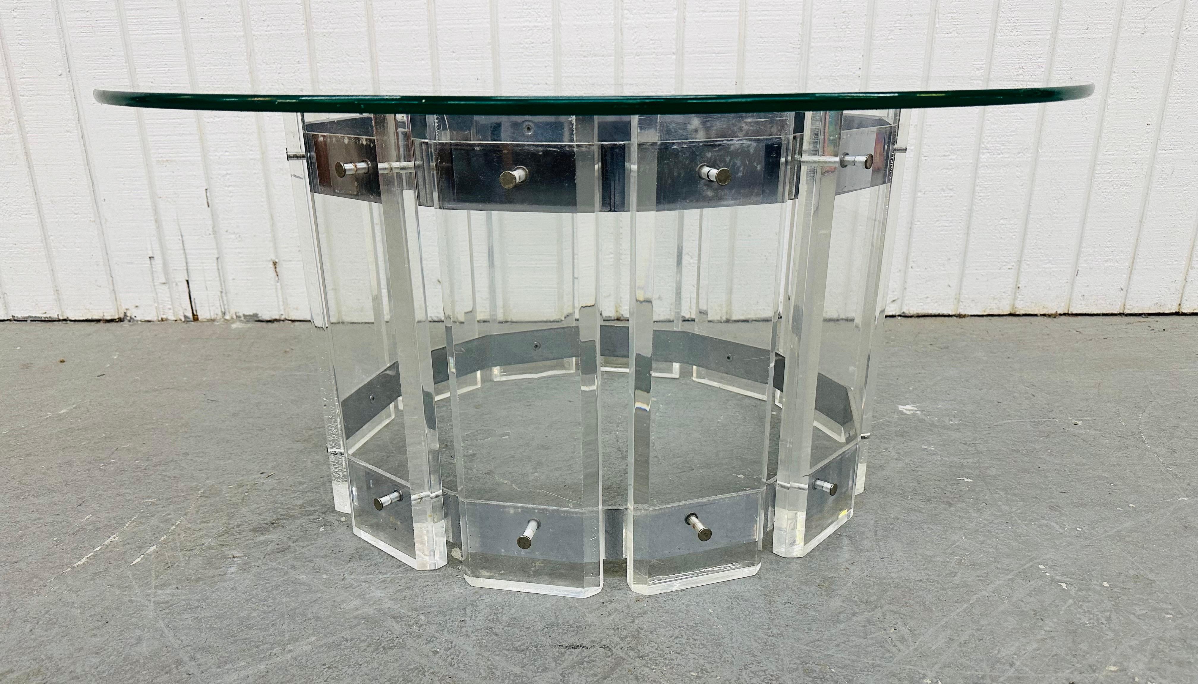 Cette annonce concerne une table basse en lucite avec plateau en verre, de style moderne et vintage. Elle est composée d'un plateau rond en verre, d'un socle rond en lucite et d'une ceinture chromée qui maintient la lucite ensemble. Il s'agit d'une