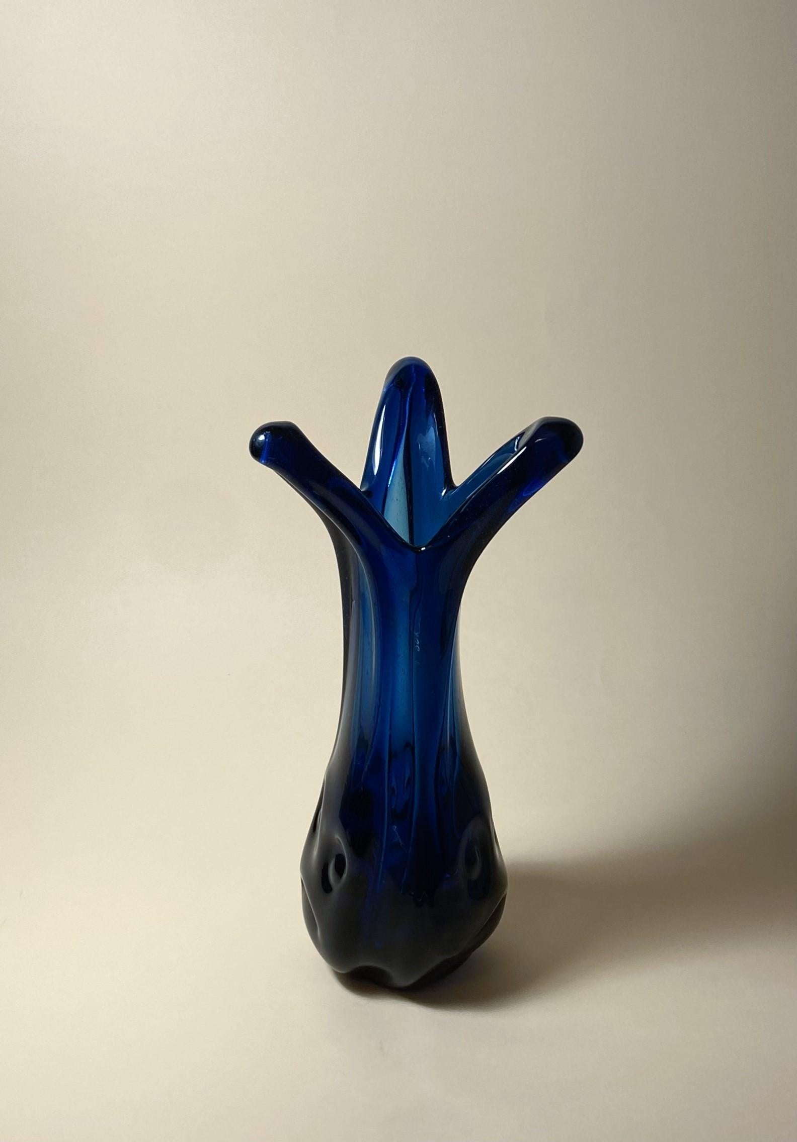 Questo vaso in vetro vintage è un pezzo unico che aggiungerà un tocco di moderna eleganza a qualsiasi spazio. Realizzato a mano in Ungheria da Budveszel Gyula negli anni '90, questo vaso presenta un design colorato ed è realizzato in vetro soffiato