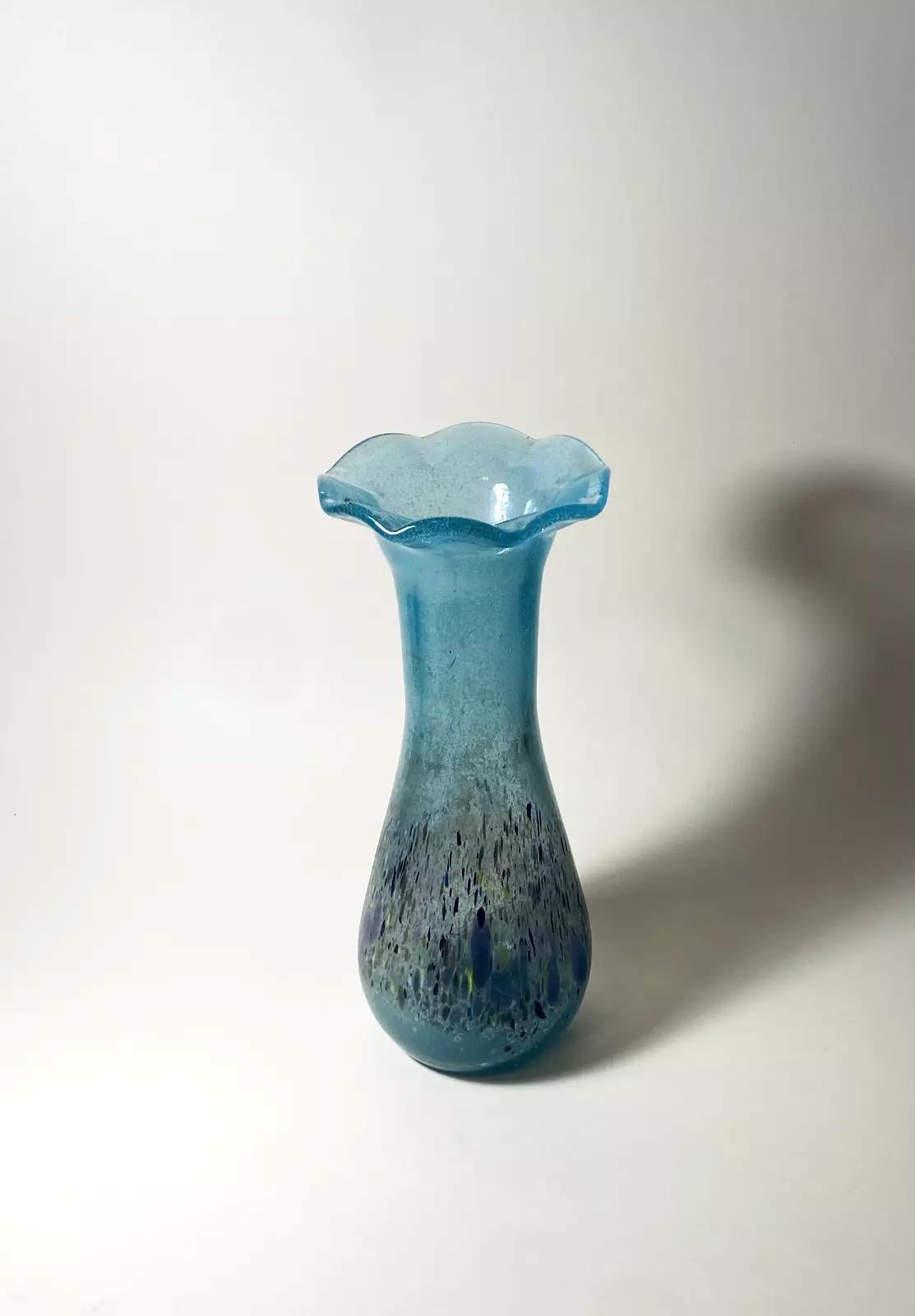 Questo vaso in vetro vintage moderno è un pezzo unico che aggiungerà un tocco di eleganza a qualsiasi arredamento. Soffiato a mano in Ungheria da Budveszel Gyula negli anni '90, questo vaso presenta un bellissimo colore blu e uno stile moderno. Con