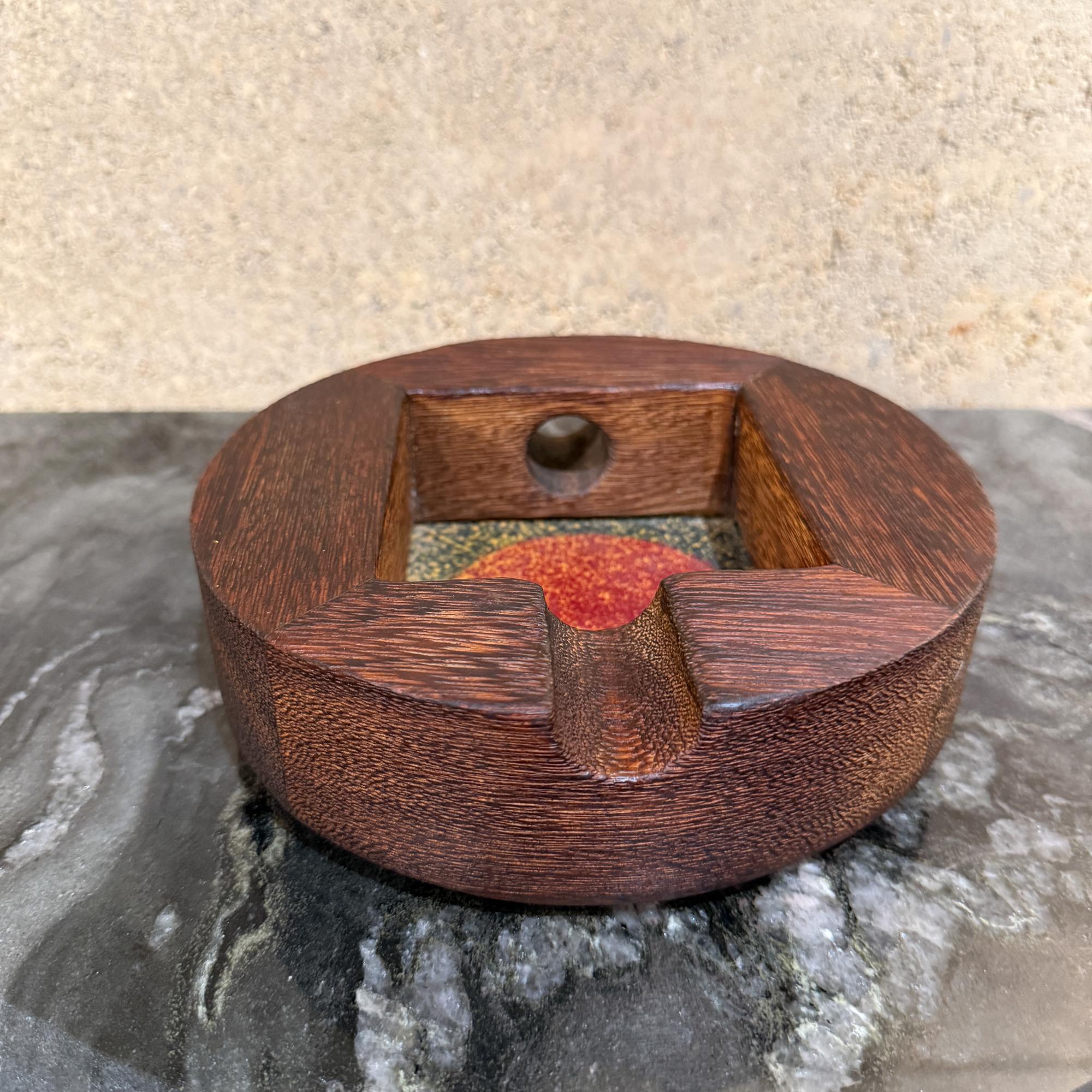 Für Ihre Betrachtung, ein Vintage moderne handgefertigte Aschenbecher aus Holz mit einem zentralen Emaille-Einsatz... Der Einsatz zeigt einen gesprenkelten, strukturierten roten Kreis auf einem dunkelgrünen Hintergrund, der ihm eine moderne Ästhetik