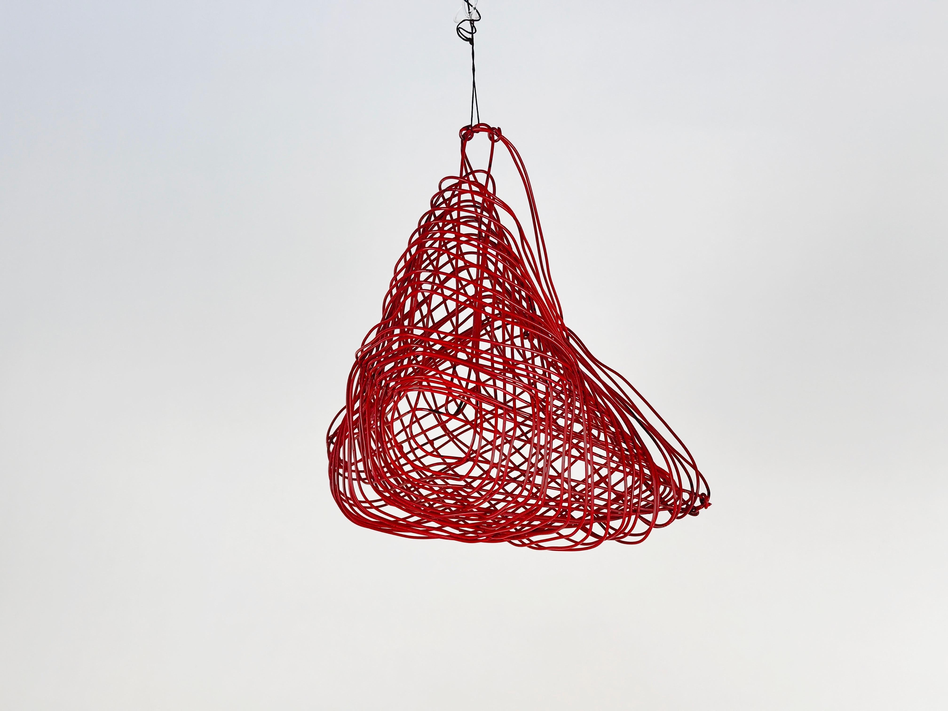 Escultura colgante de alambre de estilo geométrico móvil. El alambre parece ser un cable eléctrico con revestimiento rojo/naranja esculpido en forma de triángulo dimensional. 

Envío desde Orange, California.