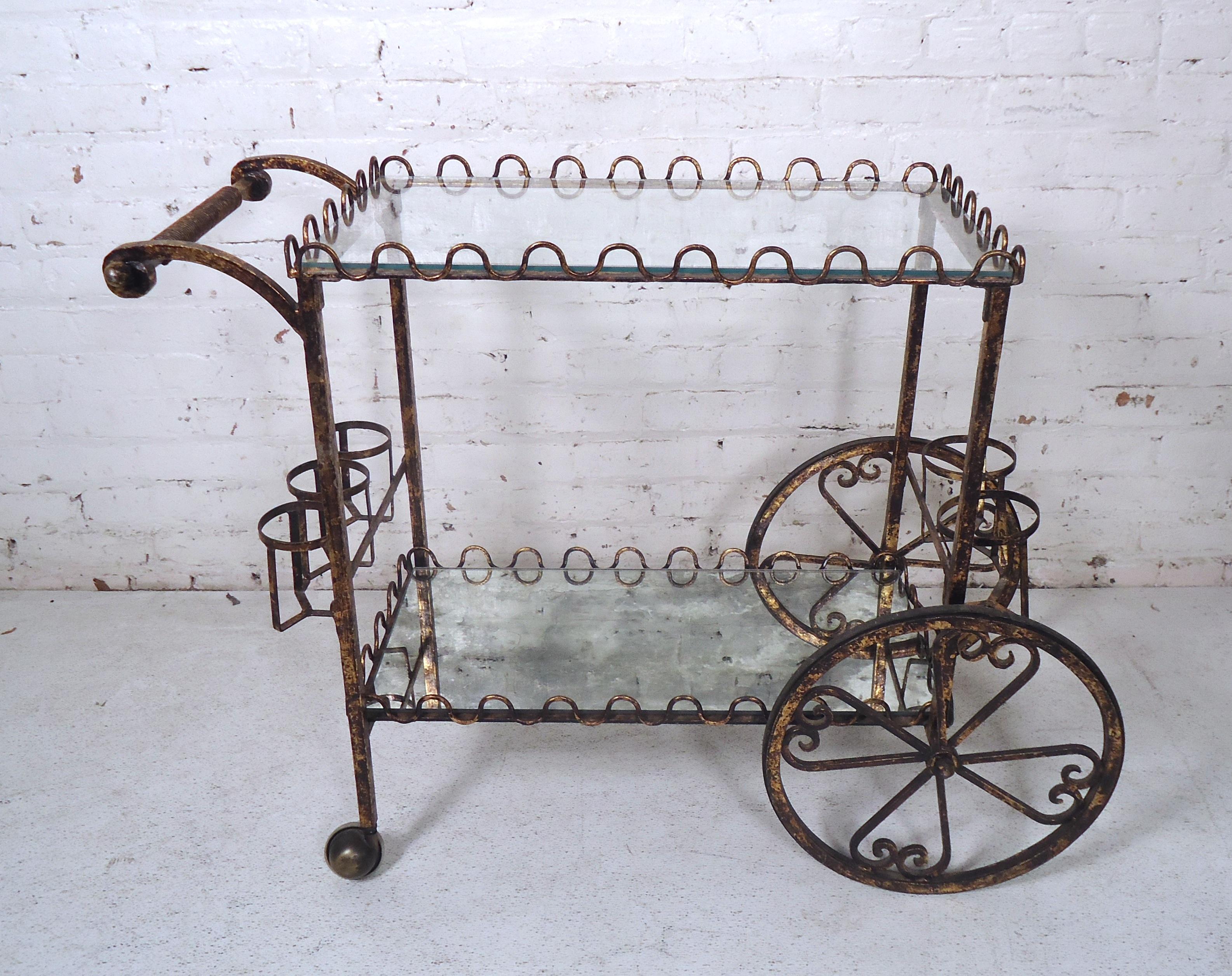 Unique Mid-Century Modern Italian bar cart featuring an iron hammered frame, set of wheels, mirrored bottom, glass top.

(Please confirm item location - NY or NJ).