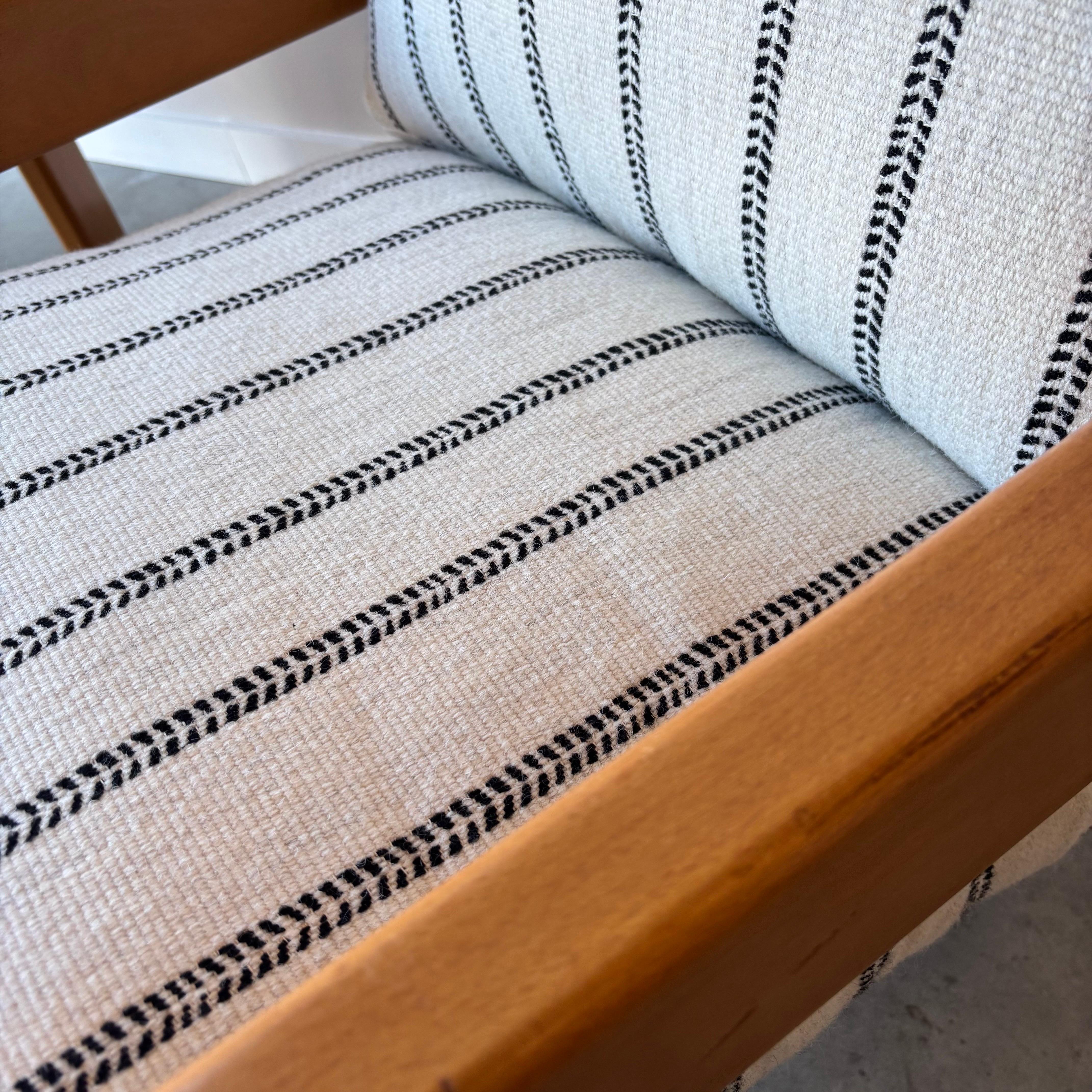 A modern pair of lounge chairs with chunky maple arms and overstuffed down cushions.  Extremely comfortable with unique wide stance yet light airy look.  New wool upholstery and down cushions.  