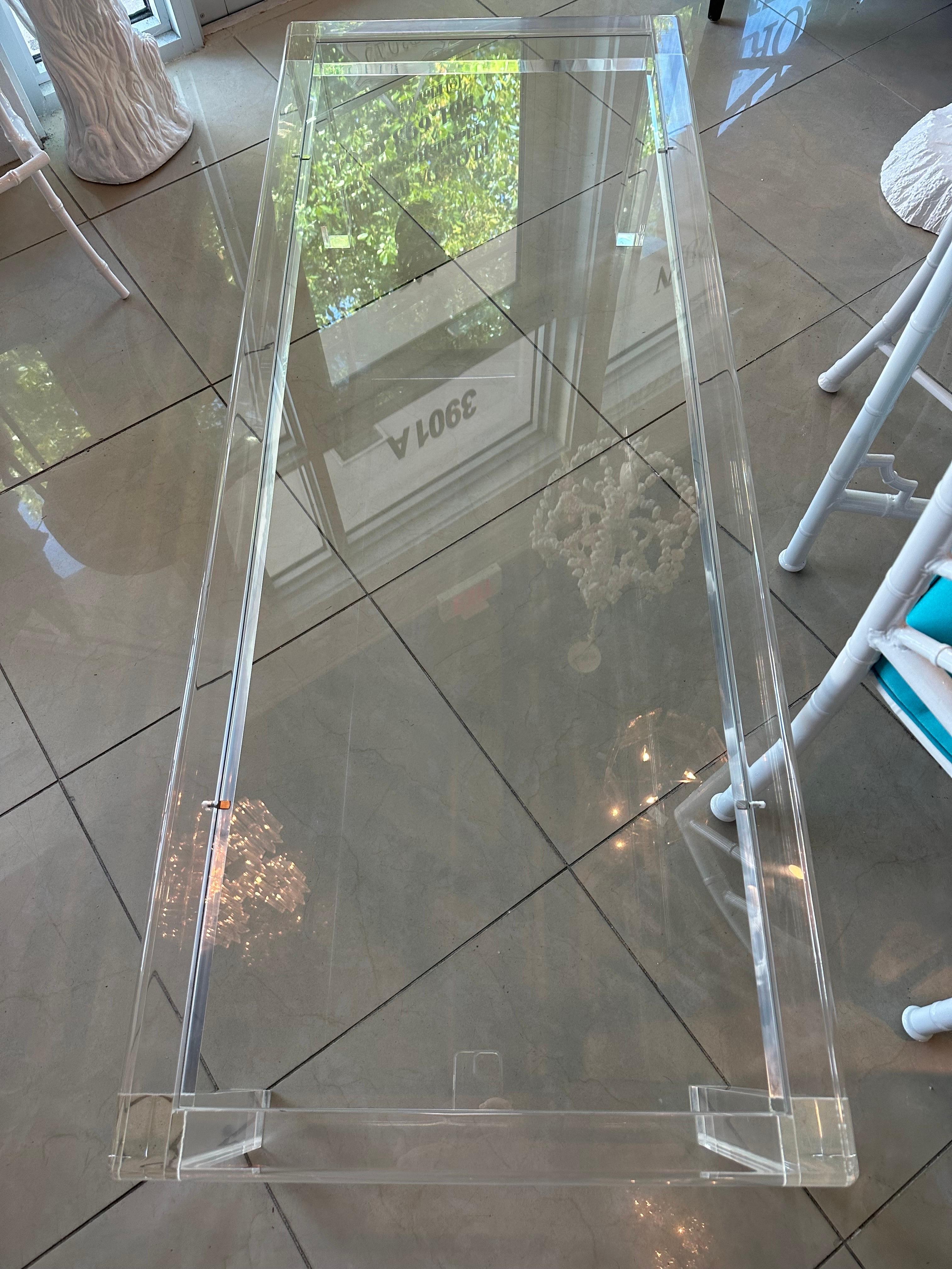 Vintage lucite coffee cocktail table with inset glass for a clean modern, sleek look. The glass top is new. The Lucite has been professionally polished. Dimensions: 15 H x 60 L x 24 D.